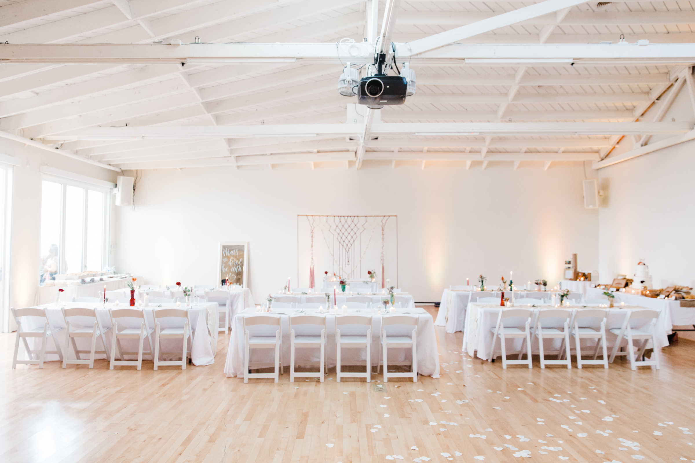 A table is set up for a farewell party, adorned with an assortment of desserts, fresh fruit, and decorative flowers.