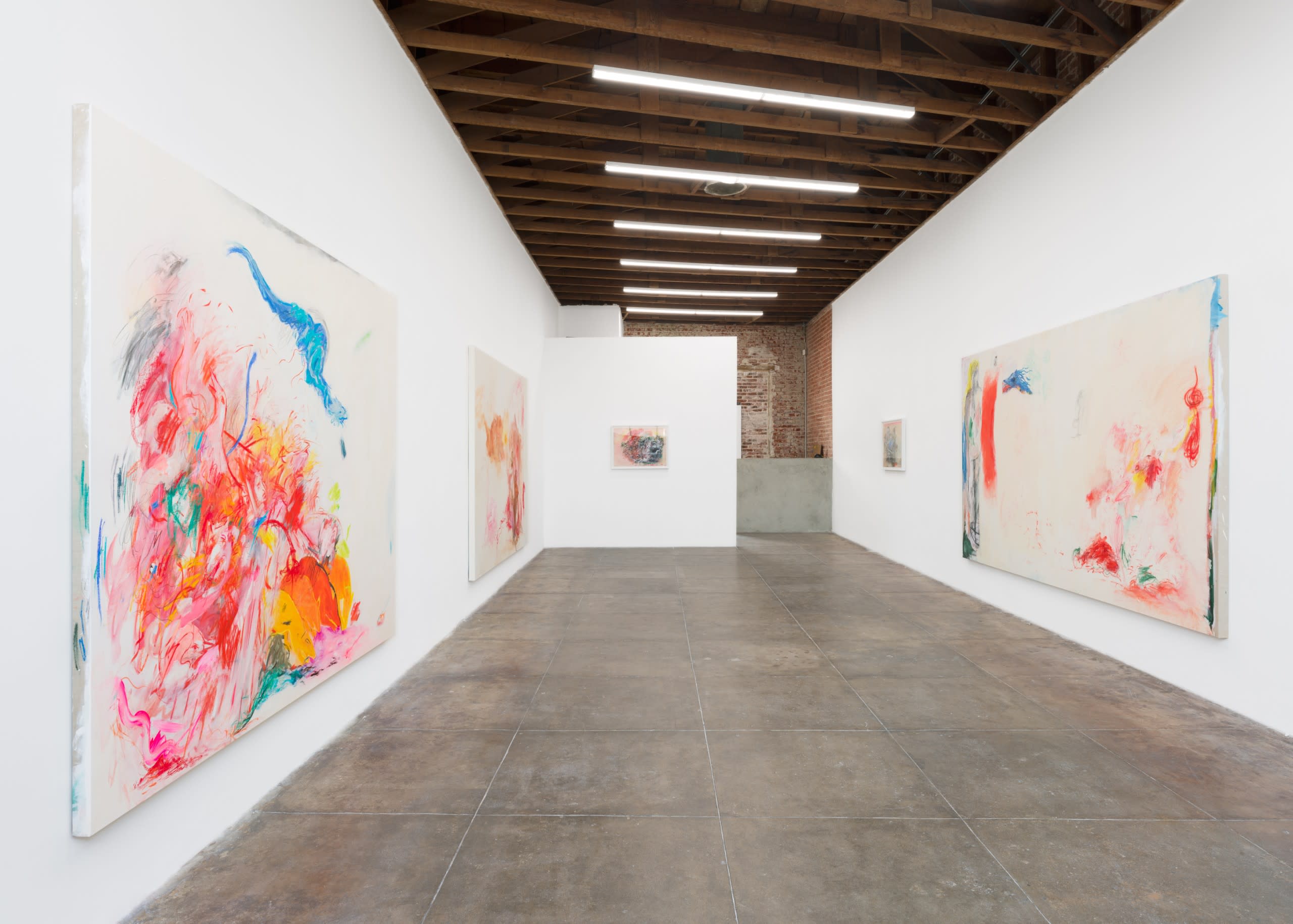 People gather in an art gallery to view exhibits and engage in conversation during an art event.