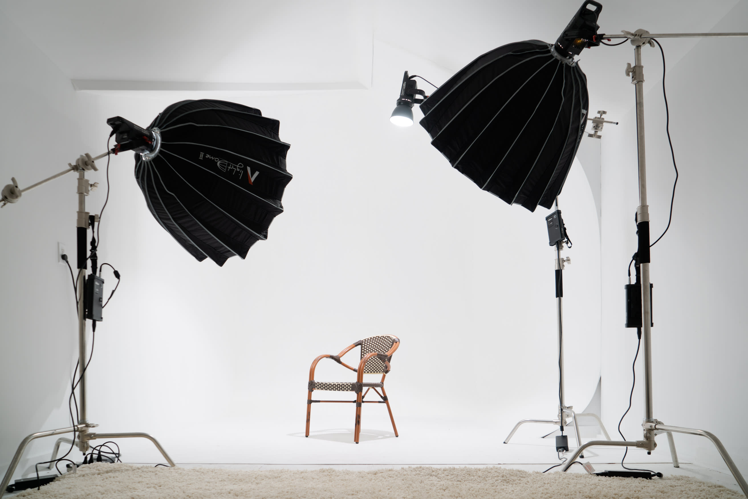 A photographer captures a model posing in a stylish outfit in a well-lit studio.