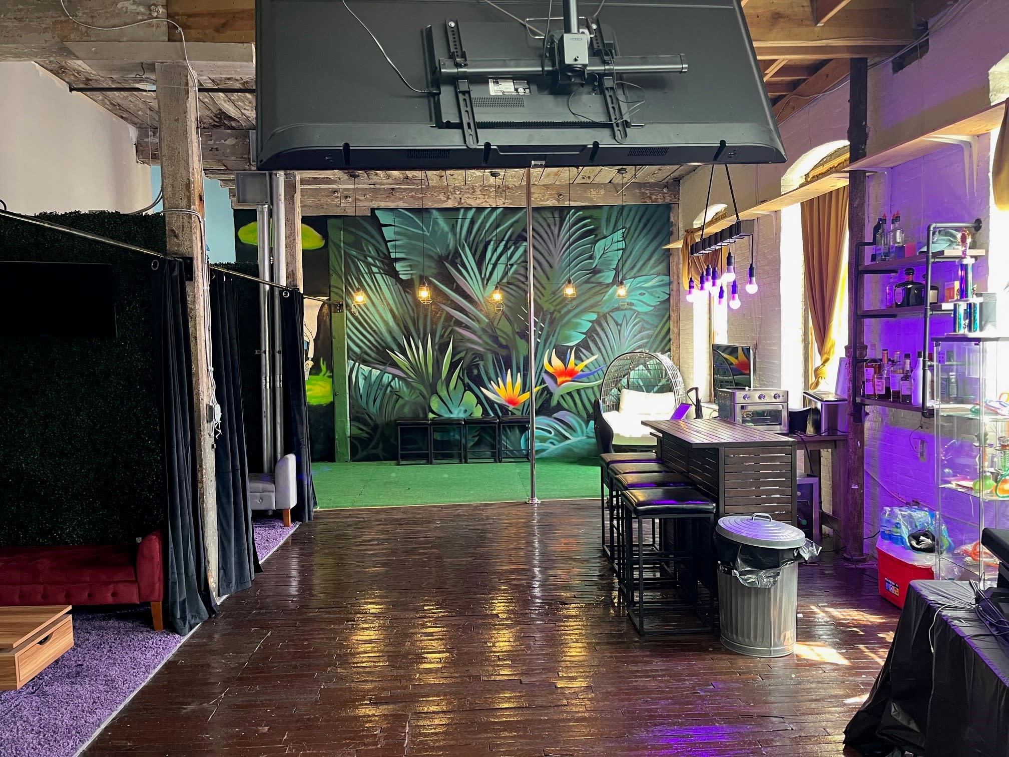 A group of people socialize and shake hands during a listening party in a stylish venue.