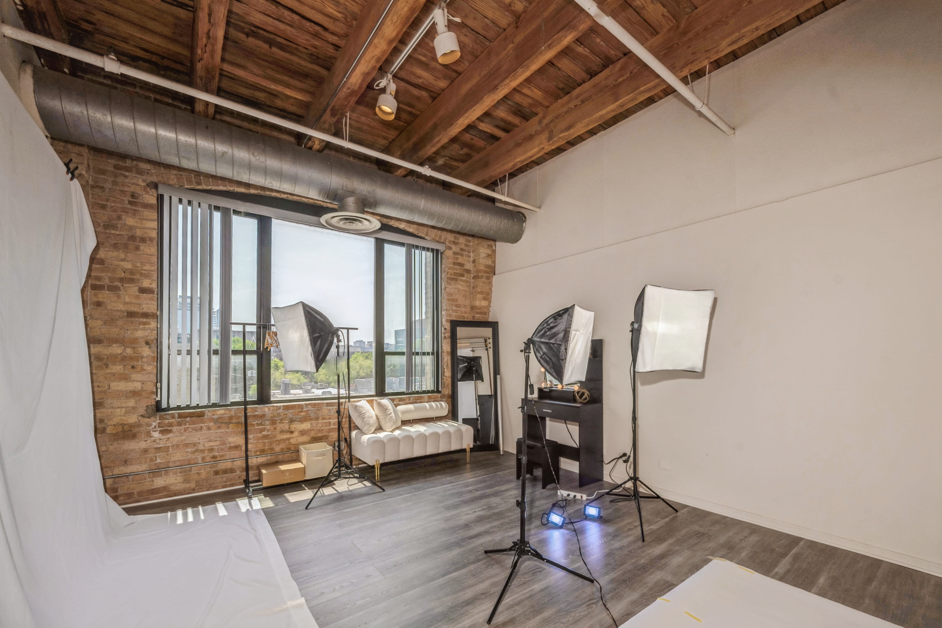 A director's chair stands alone against a plain backdrop, with studio lights positioned to illuminate the scene.