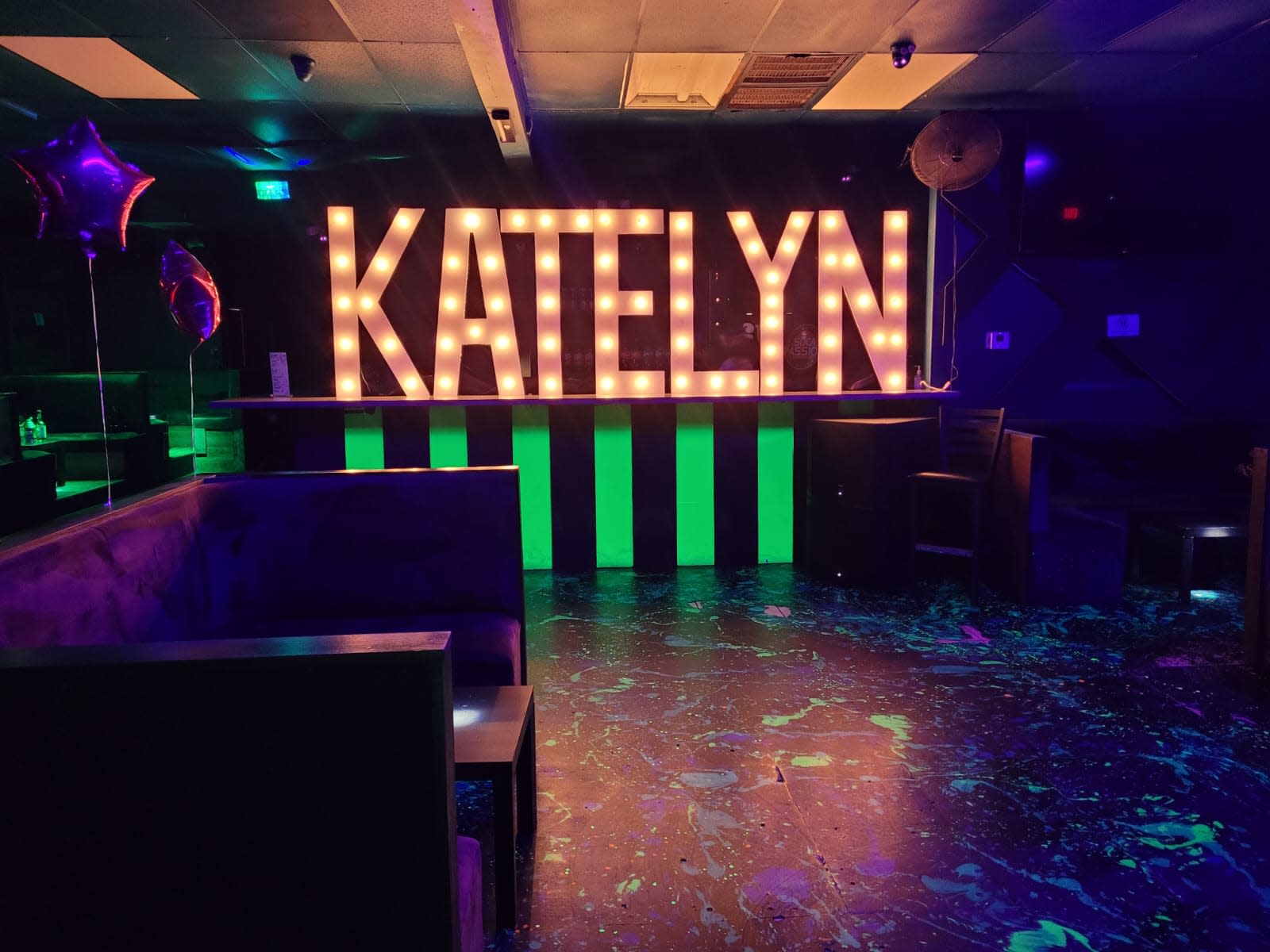 A young woman in a pink outfit exits a decorated venue with balloons for a Sweet 16 celebration.
