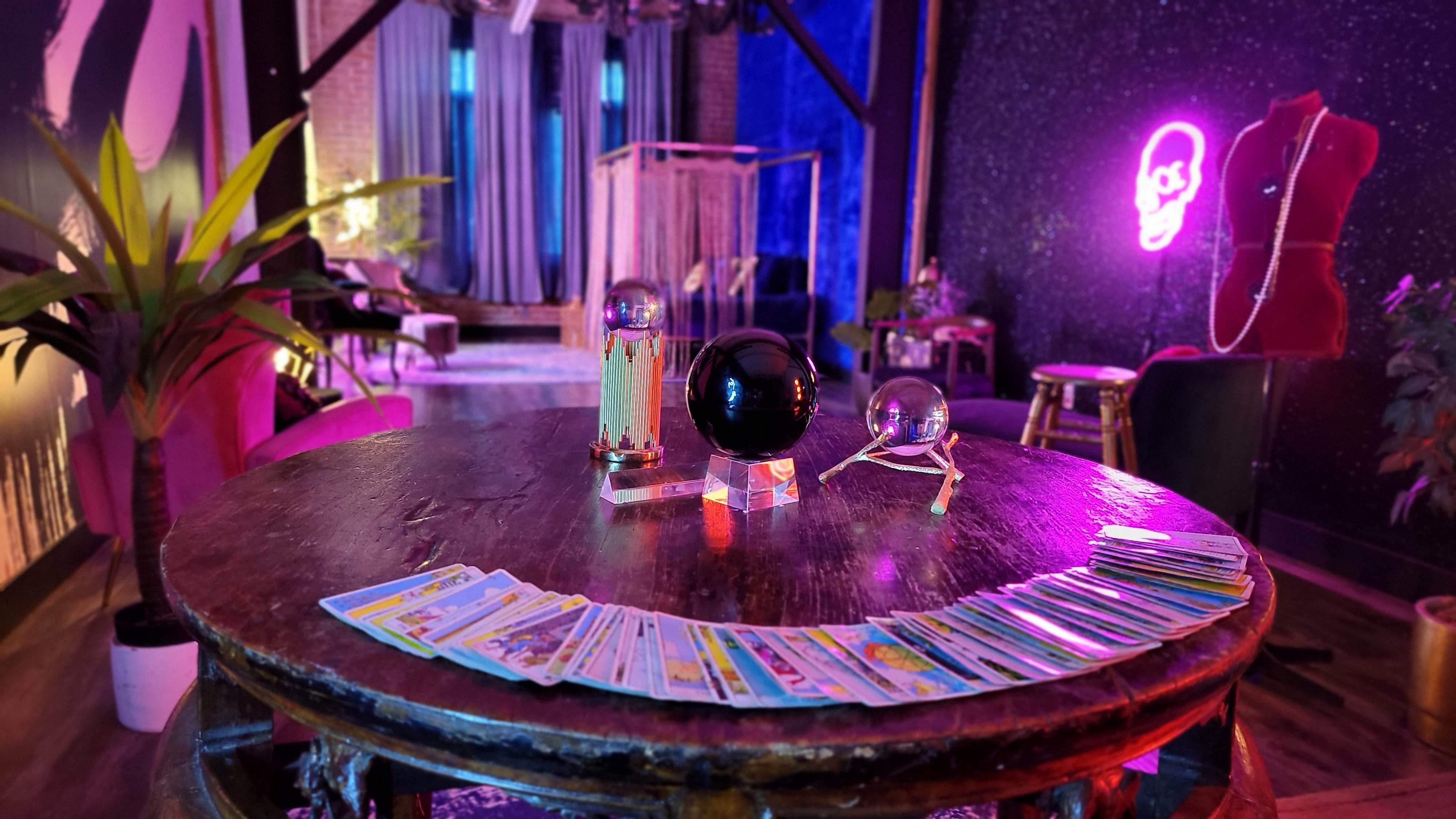 A person sits on a bed holding a decorated cake while surrounded by neon lights depicting silhouettes.