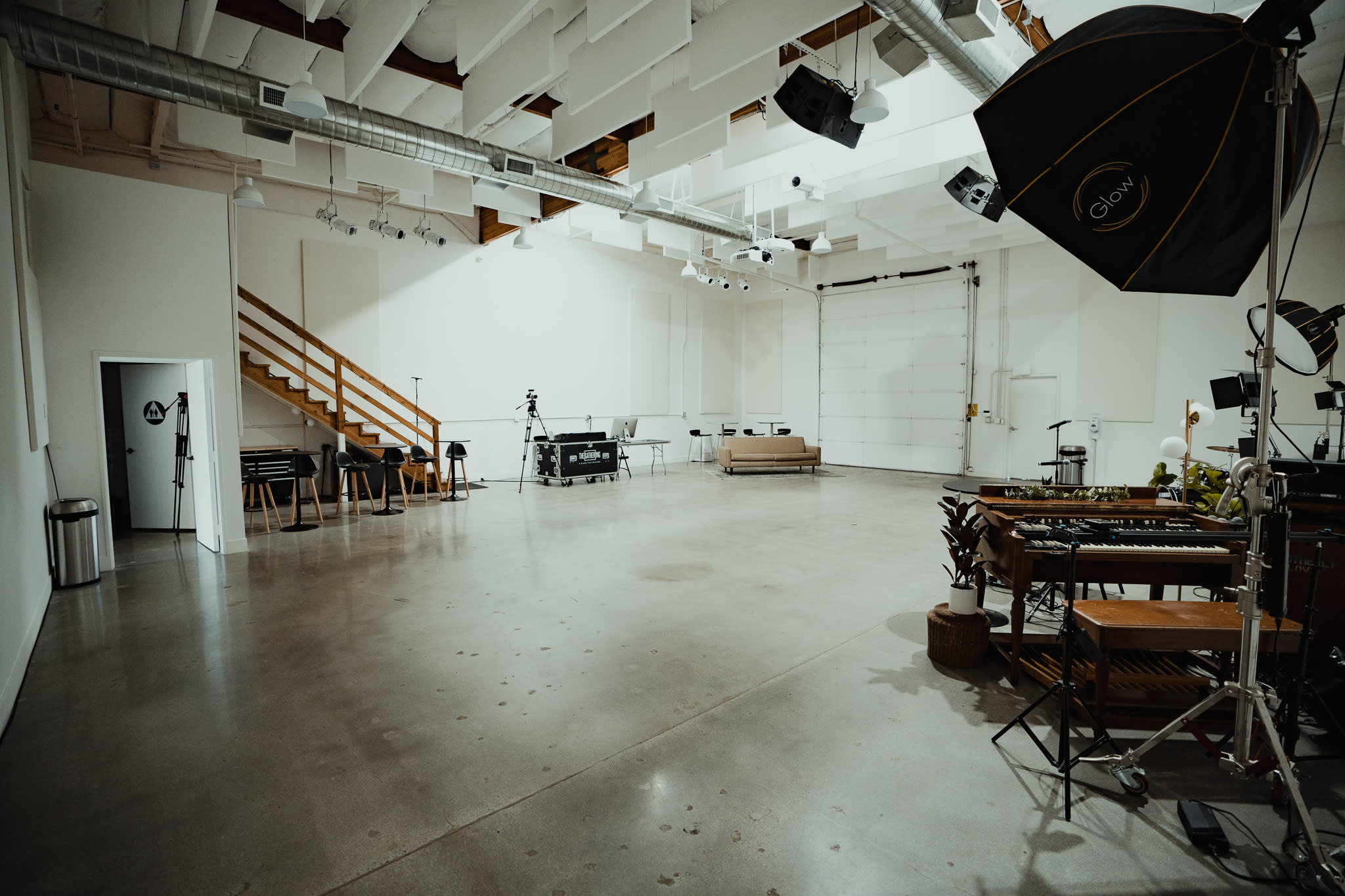 A video shoot is taking place in a foggy studio, featuring musical instruments and lighting setups.