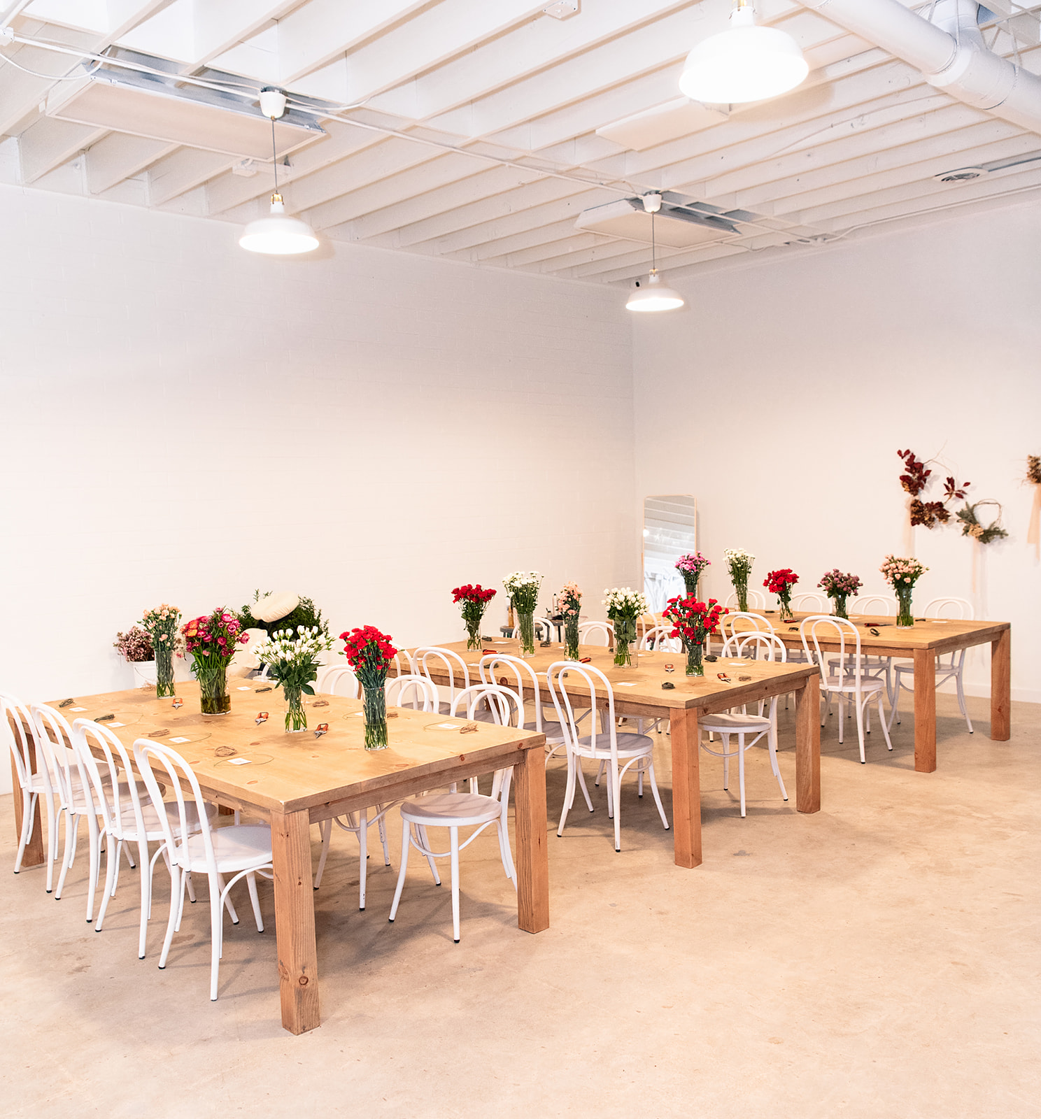 A floral arch decorated with pink and purple flowers serves as a backdrop for an elopement celebration.