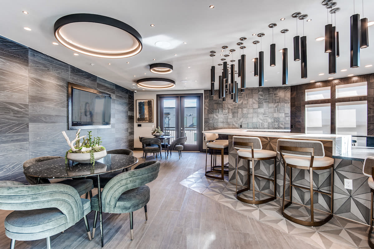 The kitchen is decorated for a birthday celebration, featuring large gold "100K" balloons and a festive party setup.