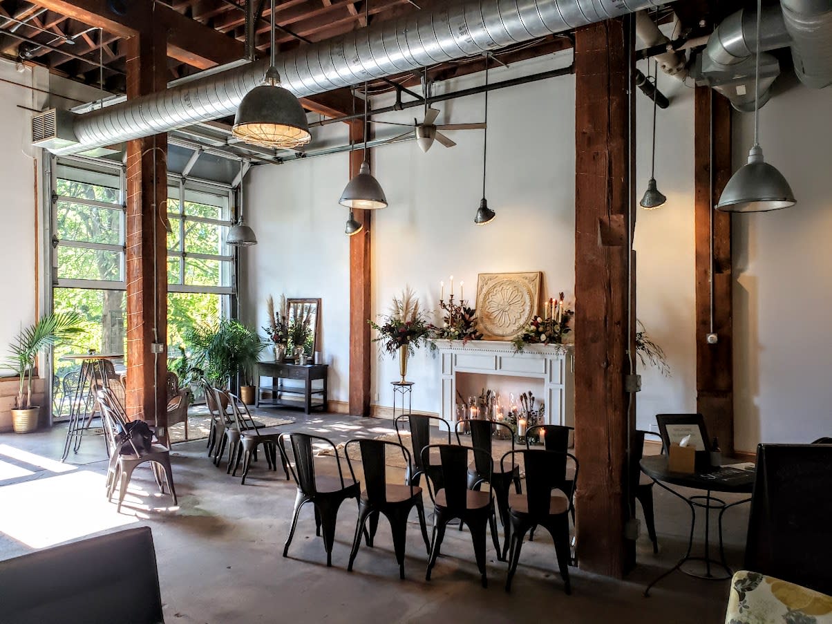 A group of women socialize and celebrate at a bridal shower in a stylishly decorated indoor venue.
