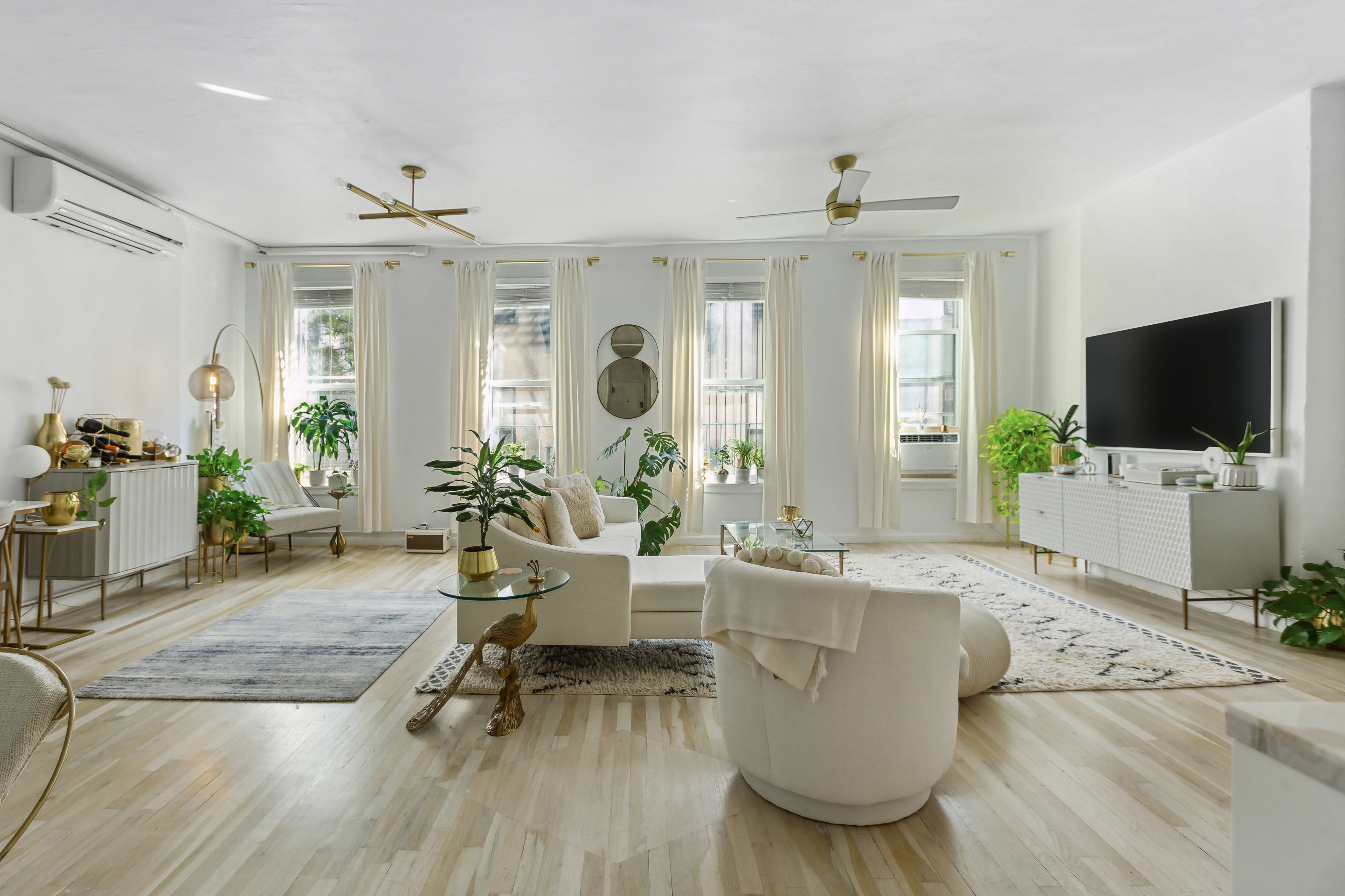 A film crew sets up equipment in a stylish living room for a short film shoot.
