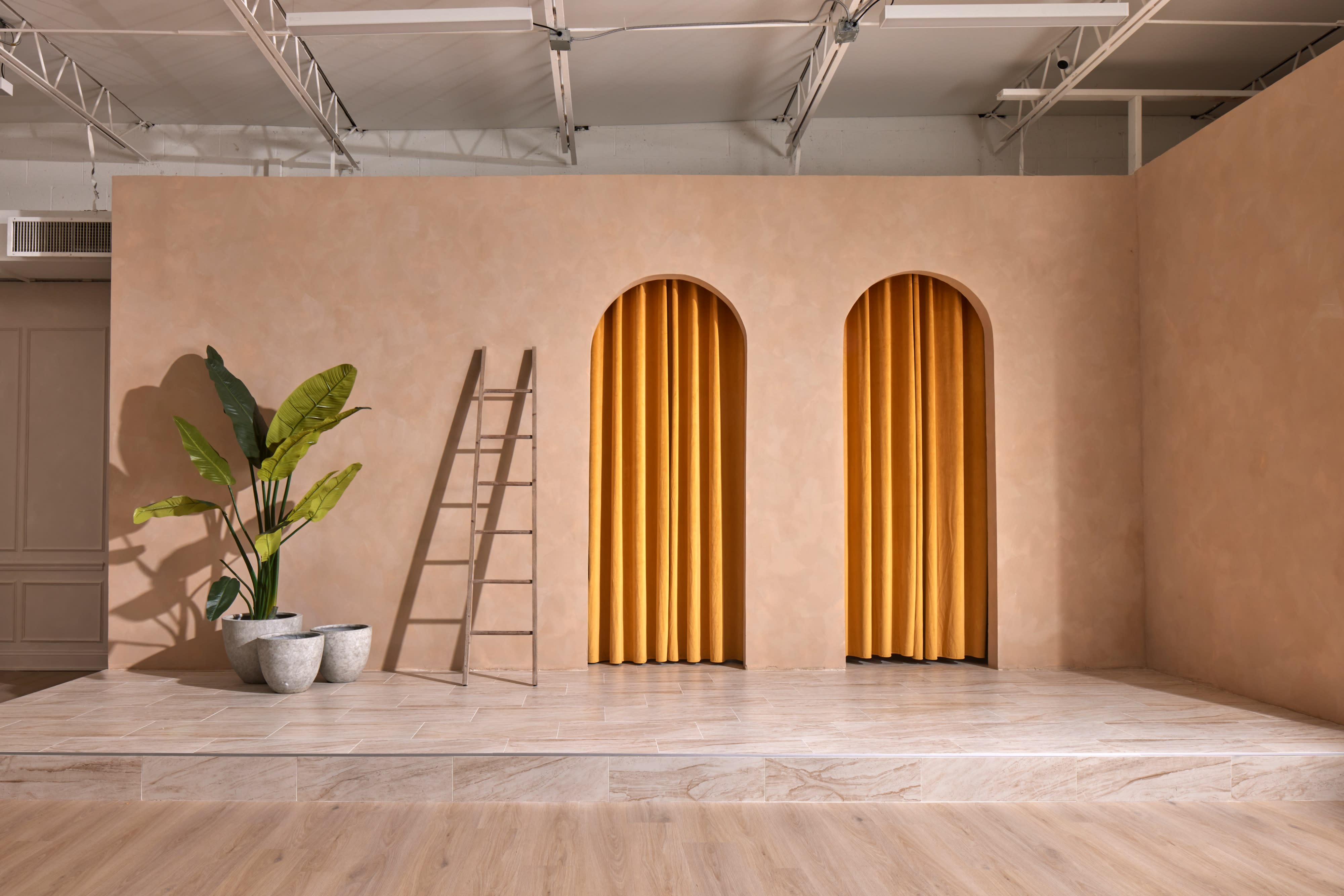 A photographer is capturing images of a model posing on steps in a studio setting.