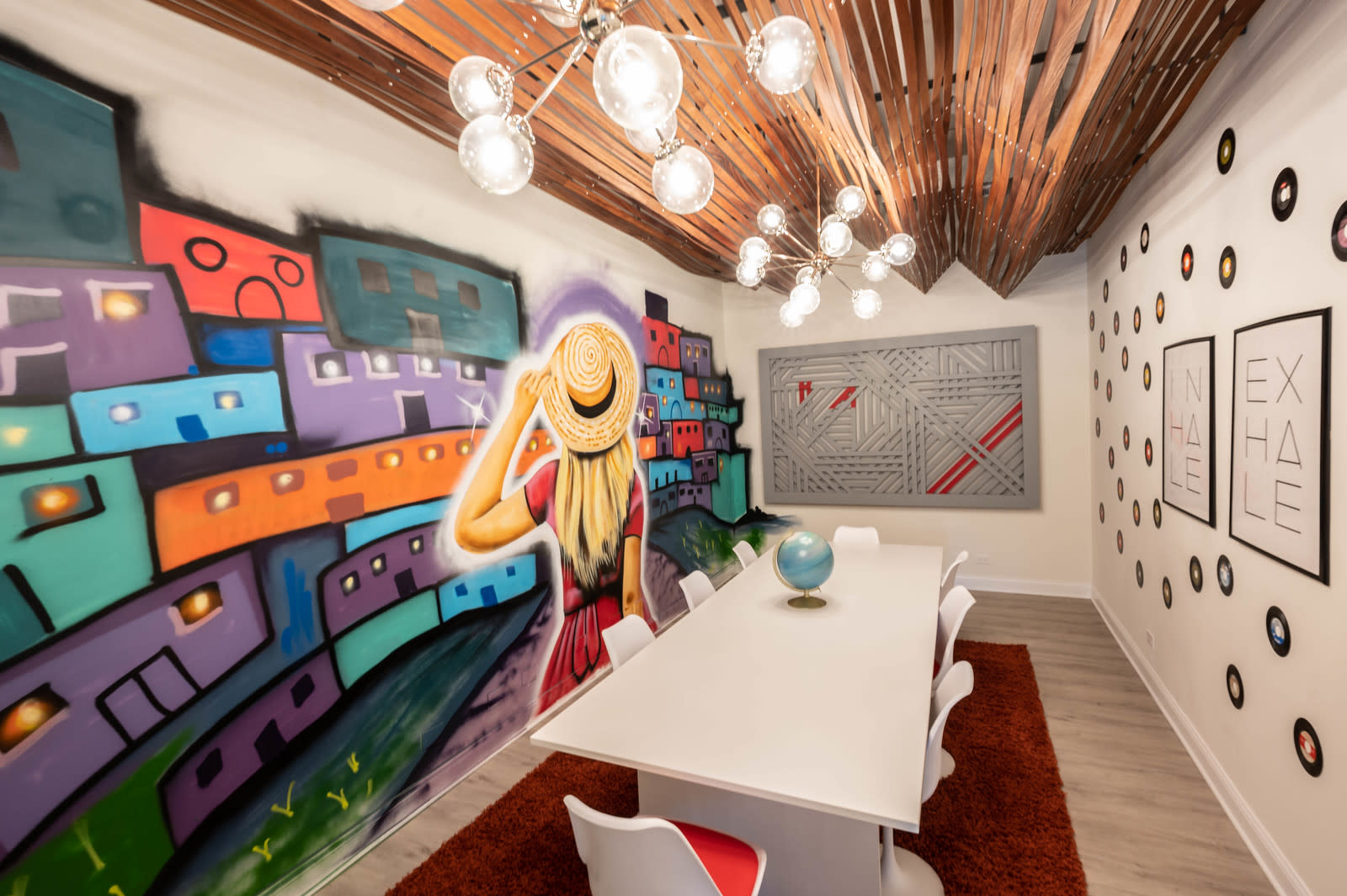 A diverse group of individuals gathers for a table reading session in a brightly lit space adorned with red decorative lights.
