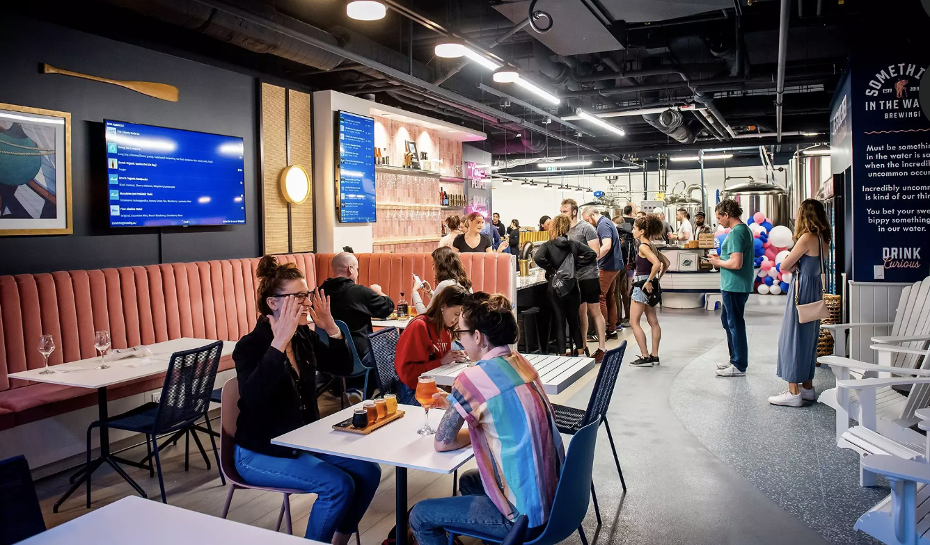 People engage in conversation and networking at a lively event in a well-lit indoor space.