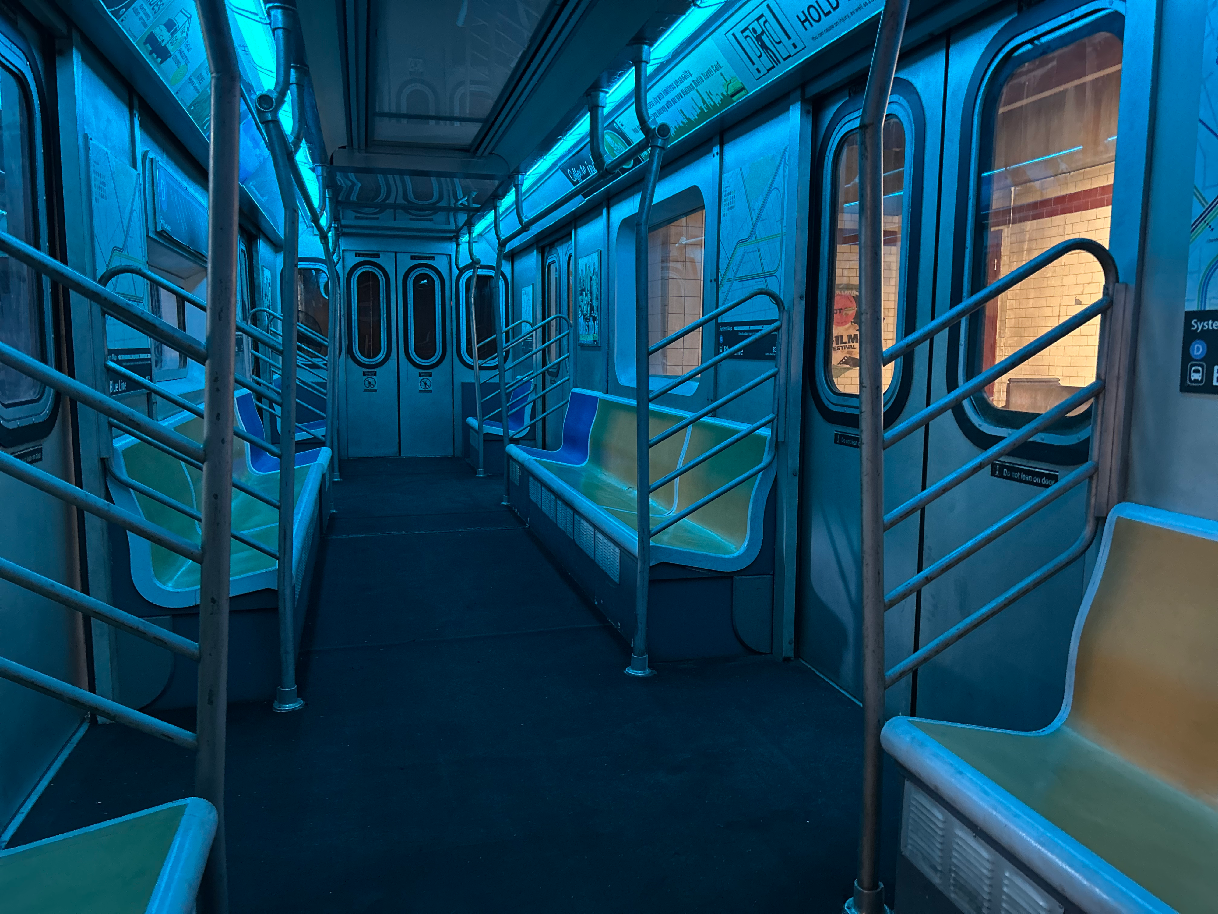 A model poses in a subway train wearing a black oversized shirt, mini shorts, and high heels while balancing a soccer ball on the floor.