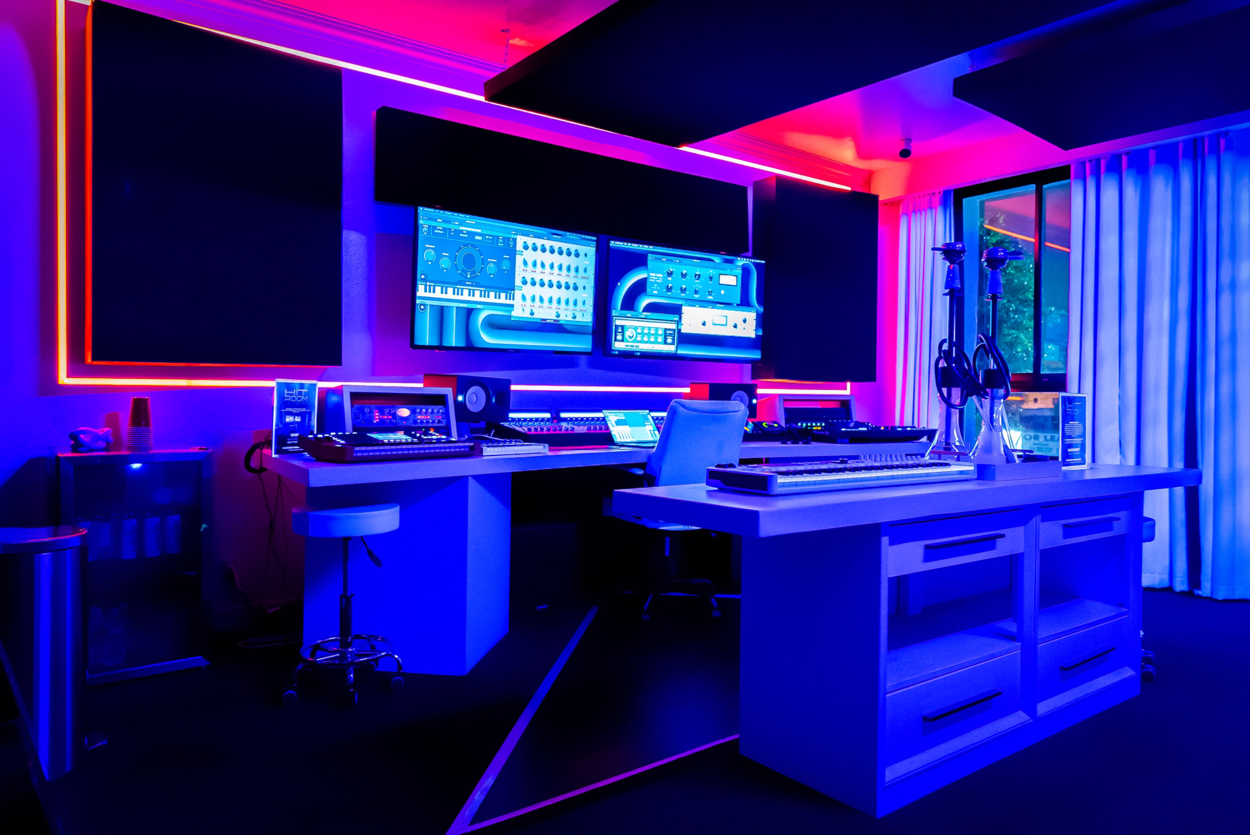 A single white chair is positioned in a soundproof recording studio illuminated with blue lighting.
