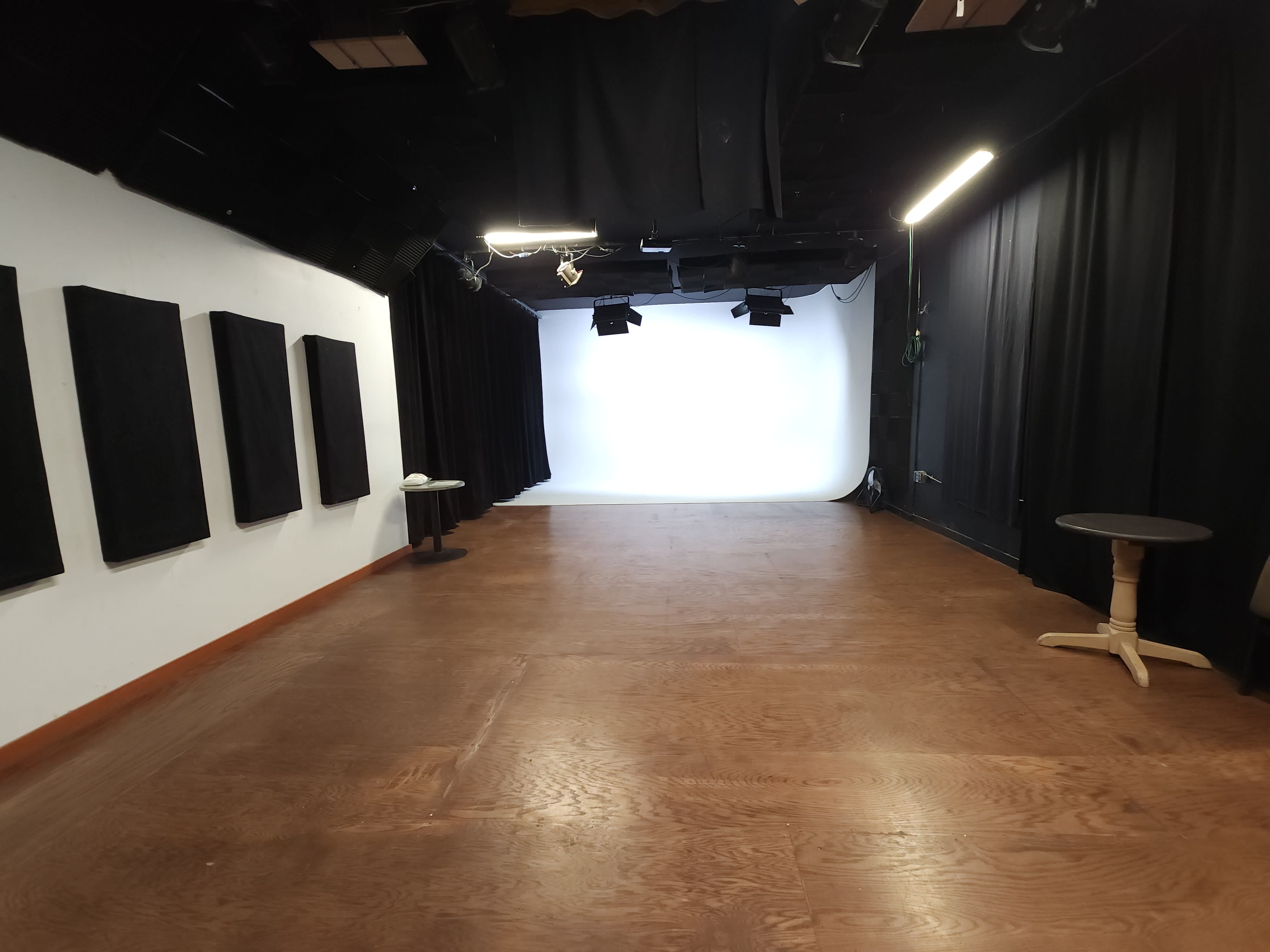 A photography studio with a gradient backdrop and lighting equipment set up for a photo shoot.