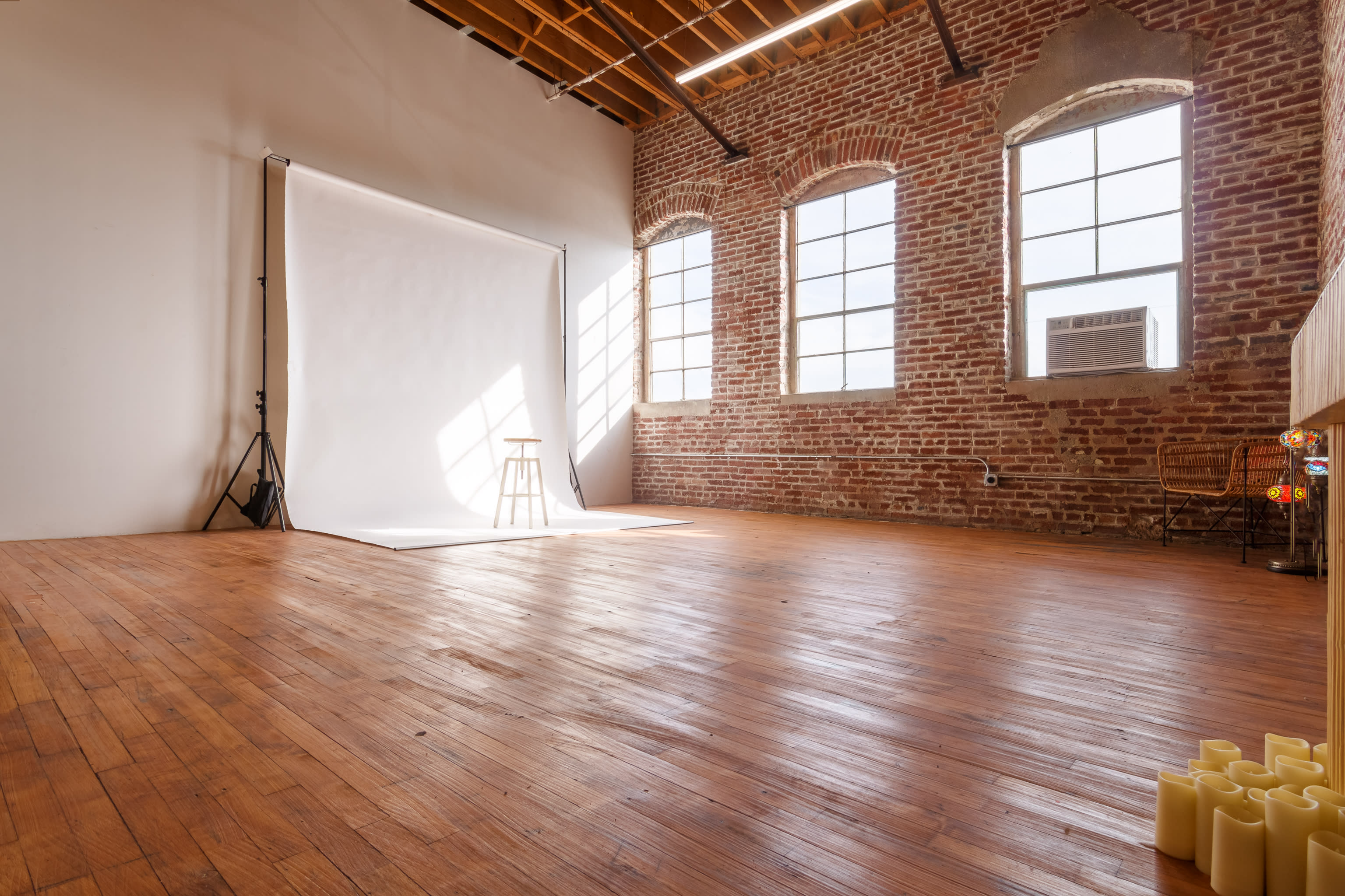A ballet dancer poses gracefully against a textured wall, showcasing her elegant form in a professional photo shoot.