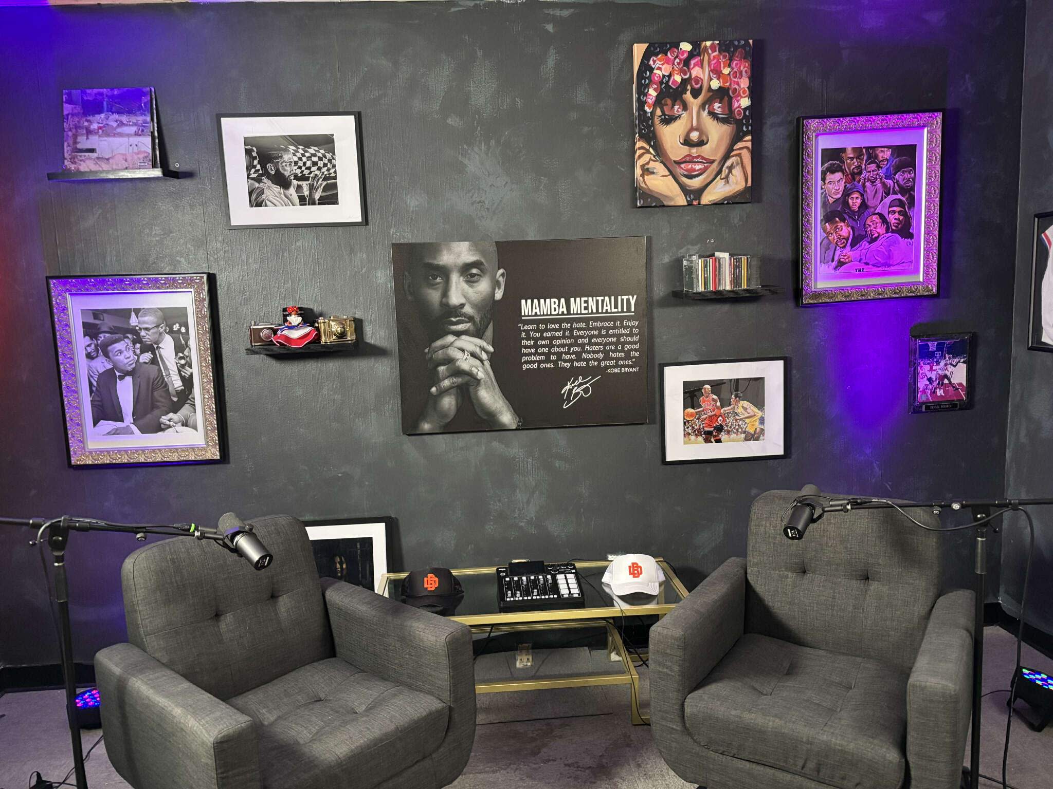 A group of four people is seated around a coffee table in a well-decorated studio, preparing to record a podcast.