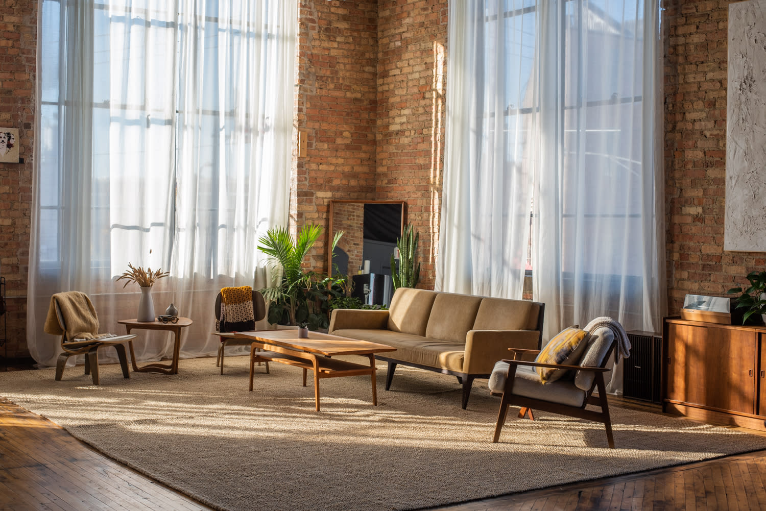 A group of five people engages in a discussion during a film screening in a spacious, well-lit living room.