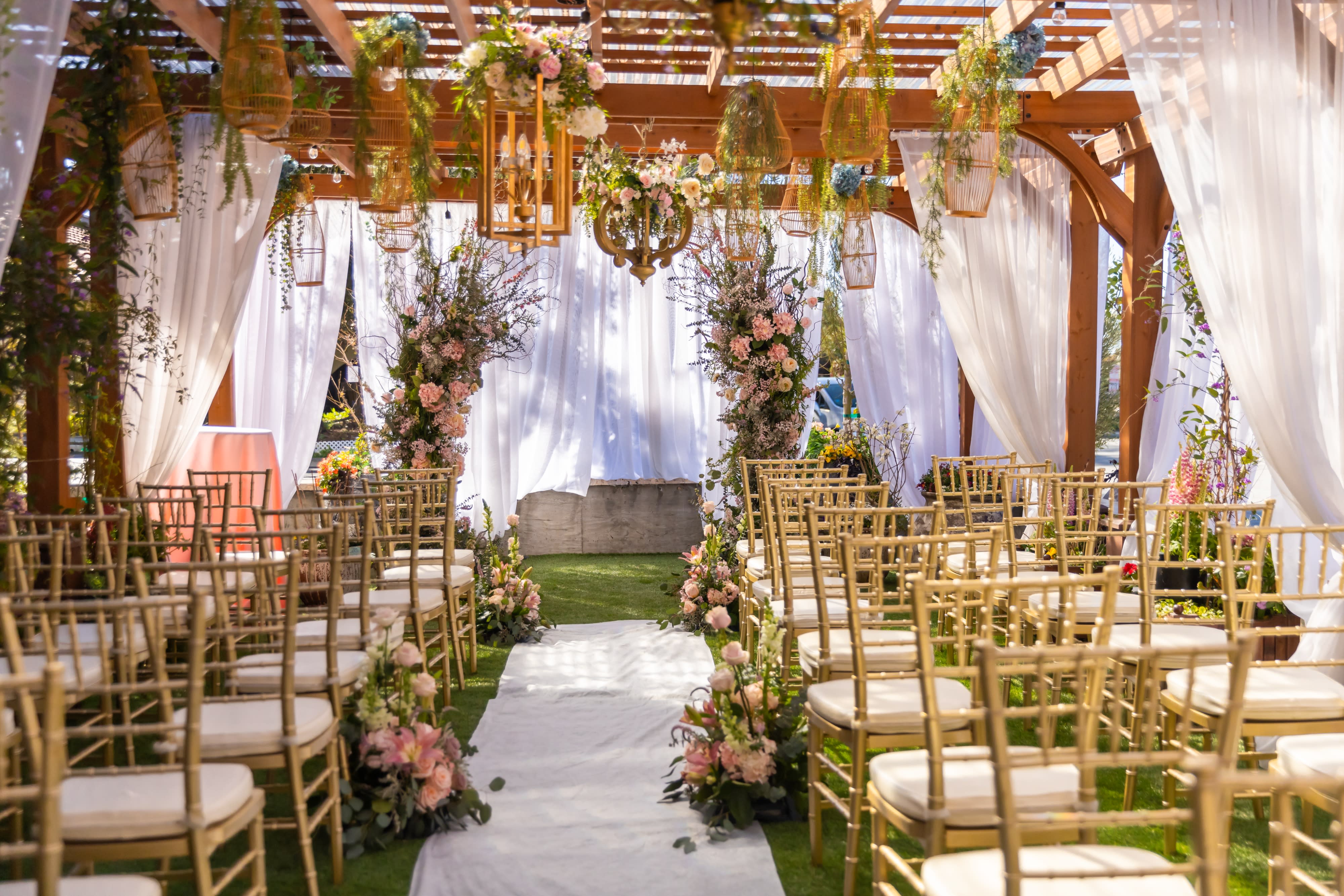 The image depicts a beautifully decorated engagement party space featuring vibrant floral arrangements, elegant table settings, and decorative displays of gifts and treats.