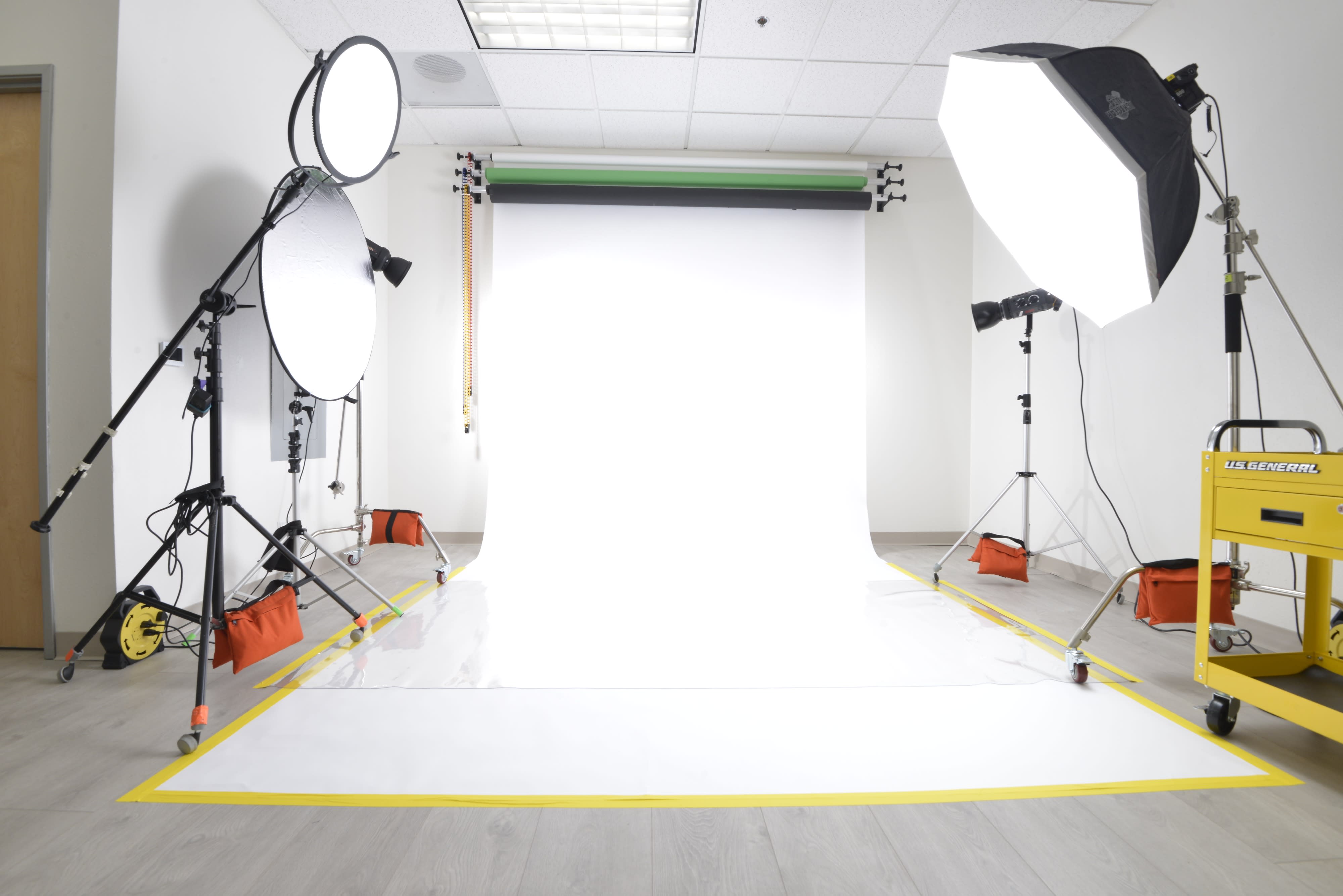 A model poses with products in a well-lit studio during a promotional photo shoot.