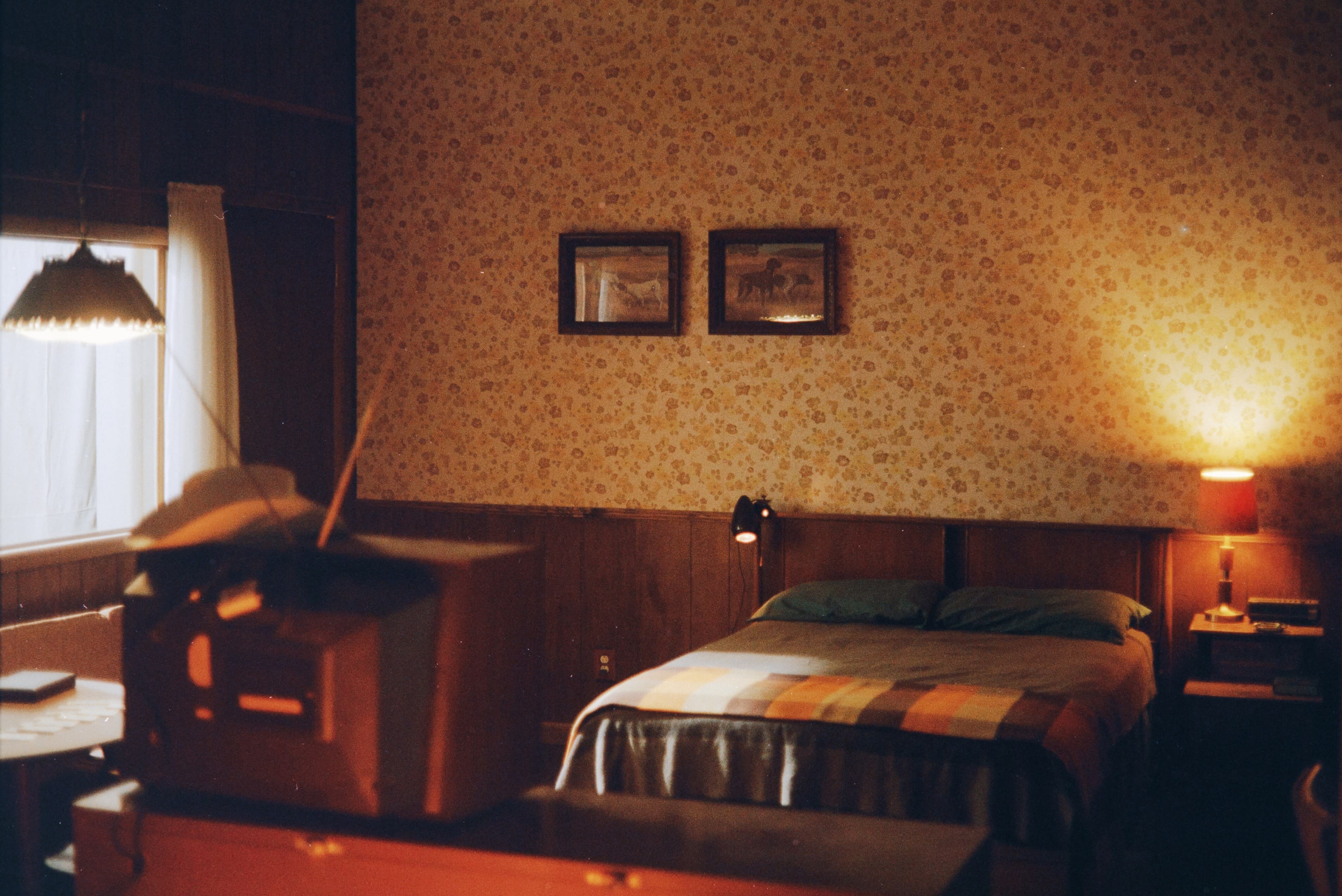 A musician plays guitar while a photographer captures the moment in a vintage-styled room.