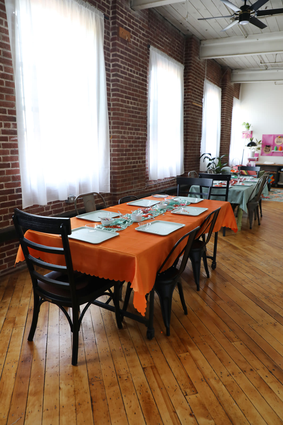 The table is set with a variety of food items, including breads, snacks, and salads, for a baby shower gathering.