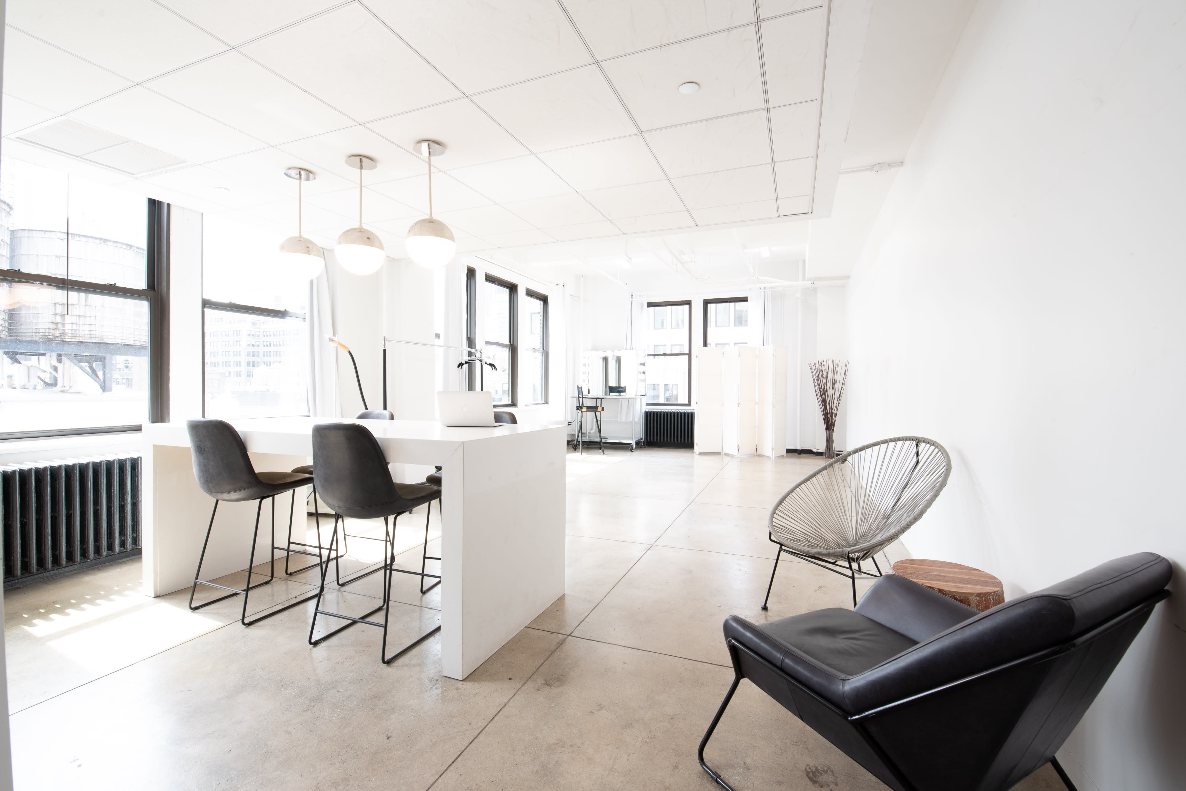 The image showcases an elegantly arranged display of assorted gourmet appetizers and desserts on a white counter in a modern kitchen setting, illuminated by pendant lights.