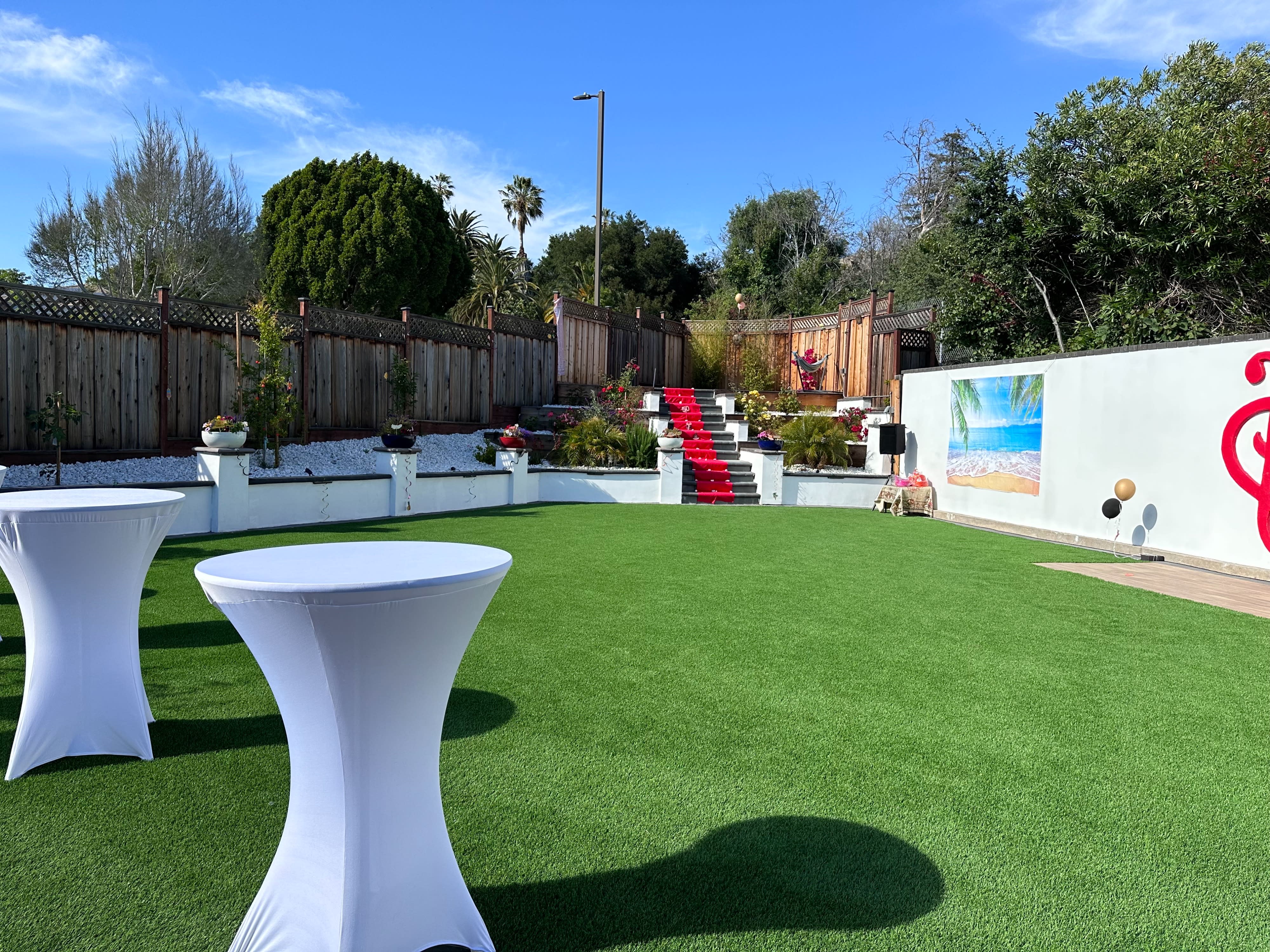 A person sets up a table in a backyard for a graduation party.