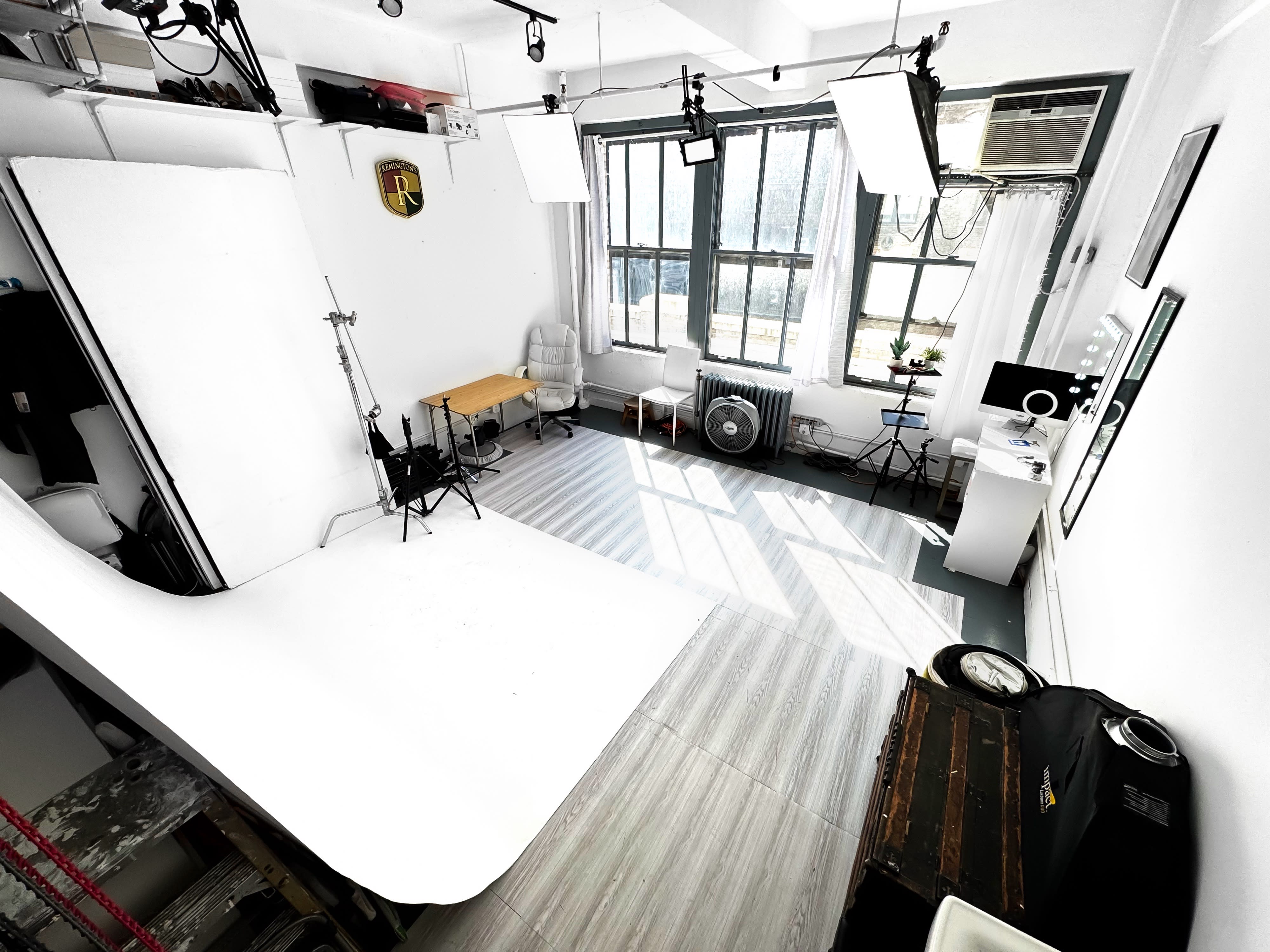 A photography studio is set up with various lighting equipment, backdrops, and props arranged for a headshot session.