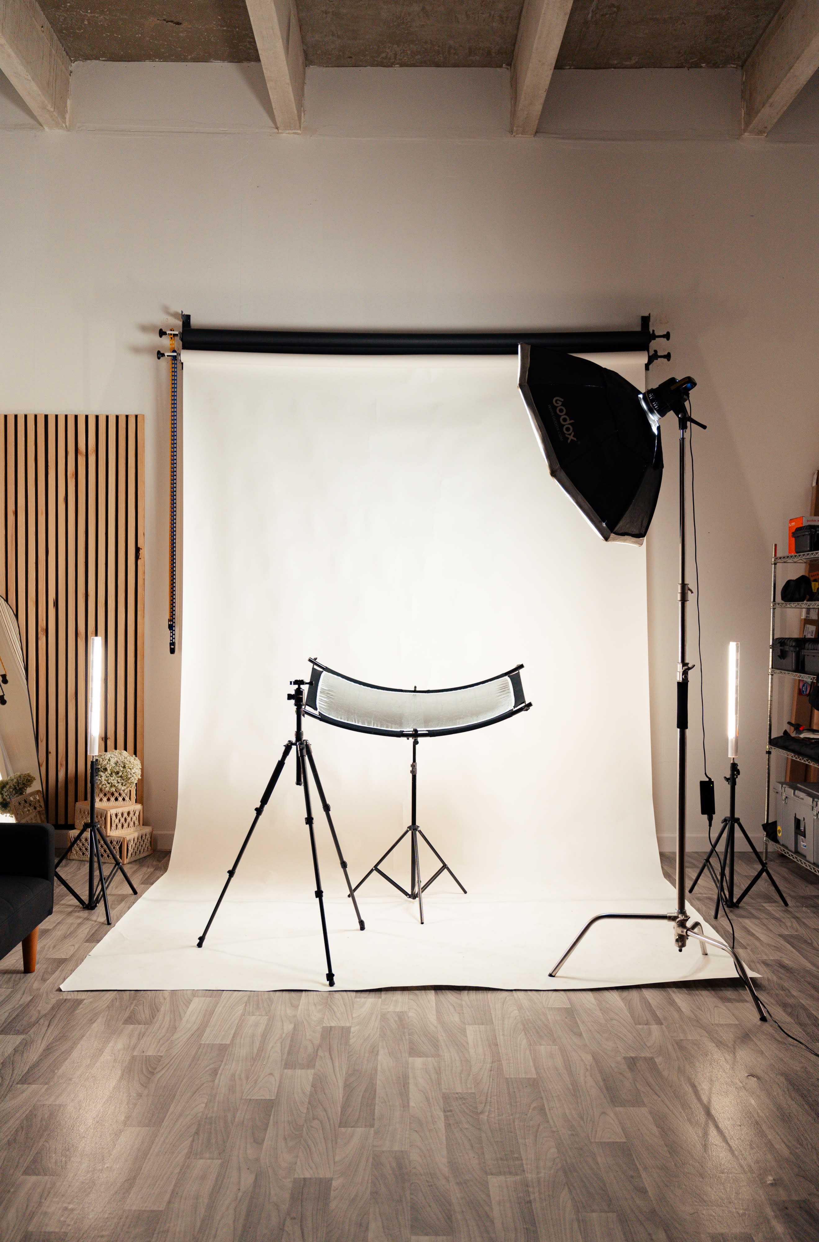 A couple shares a close moment while holding a photo strip against a light background.