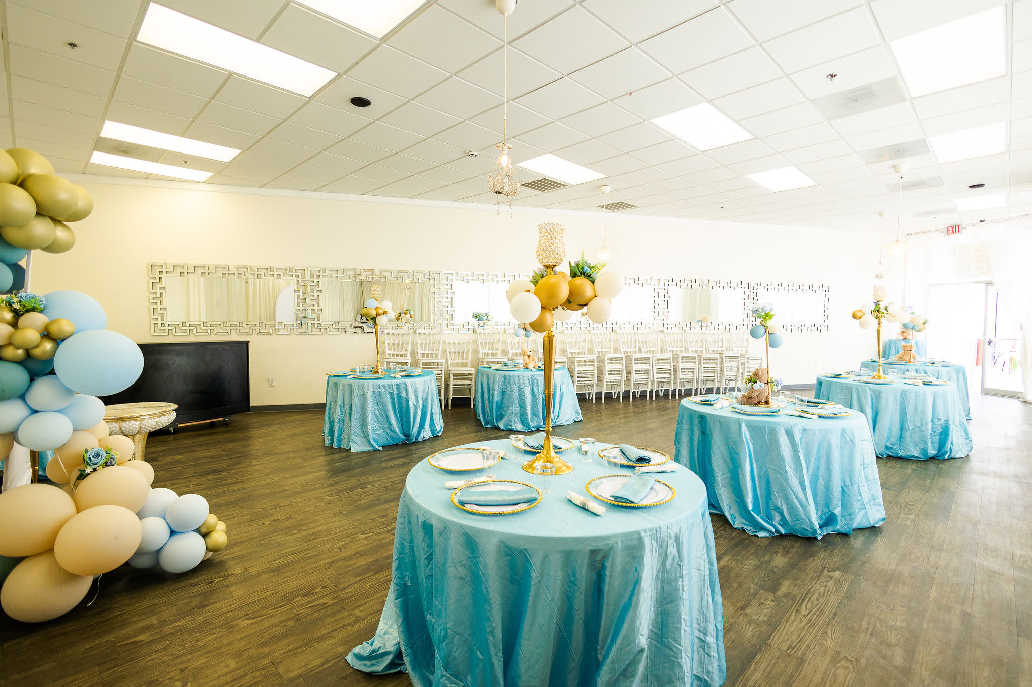 A group of women gathers around a table to enjoy food and drinks at a baby shower.