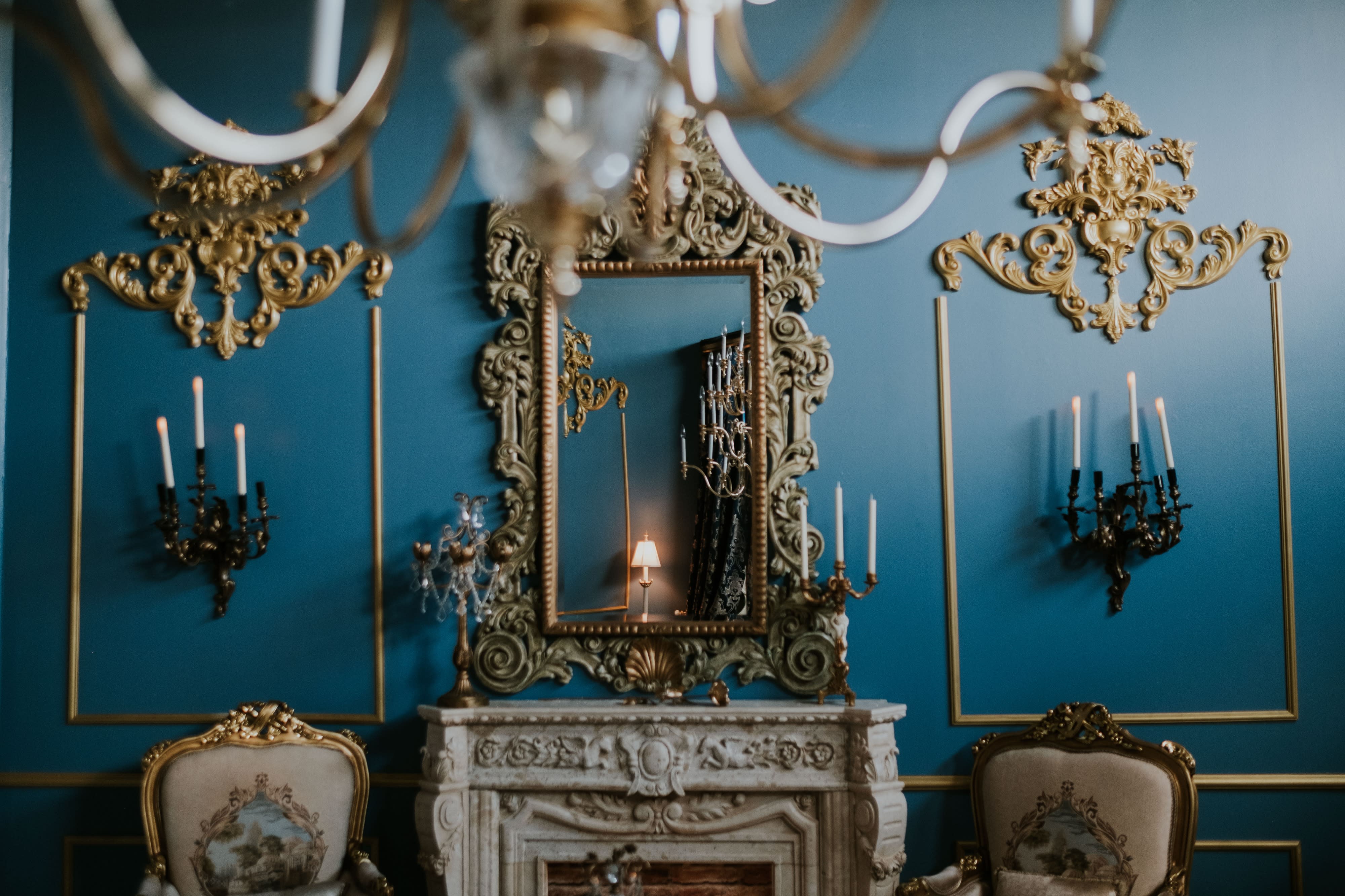 A ballet dancer poses gracefully on an ornate sofa during a photo shoot.