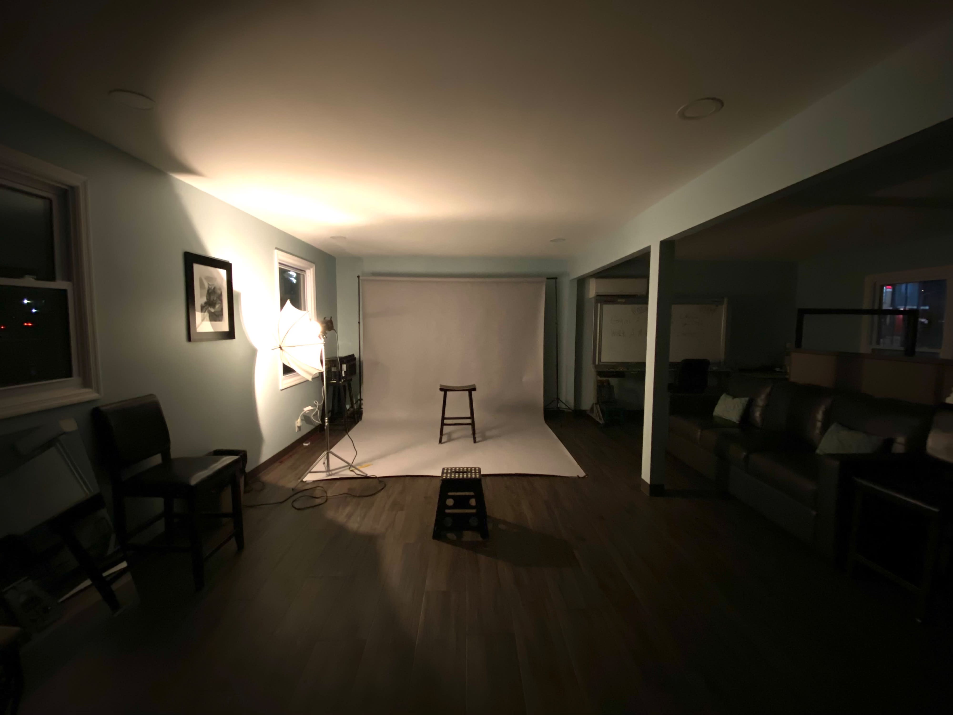 A video production team collaborates in a studio setting, preparing equipment and filming scenes with a clapperboard, actors, and lighting setups.