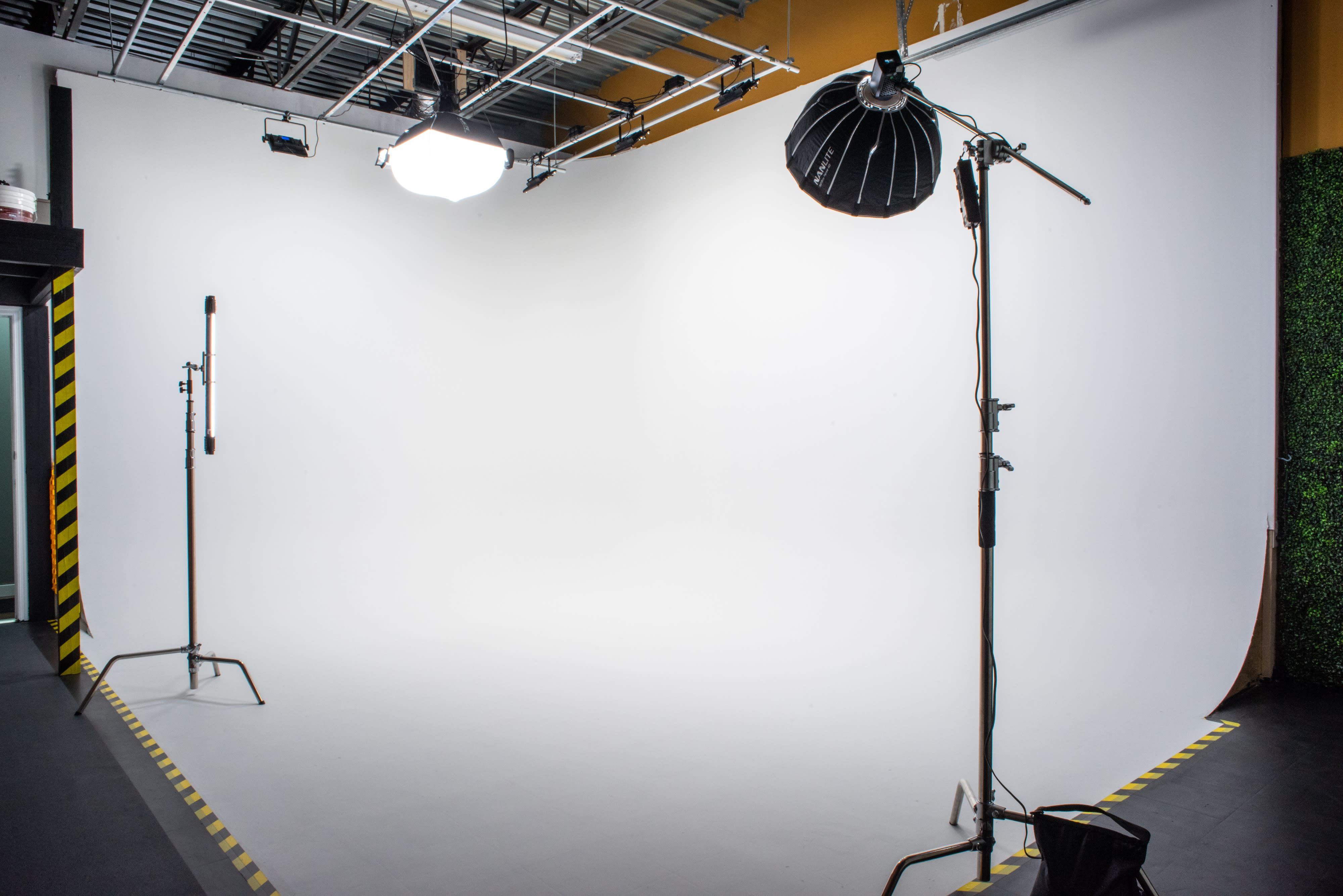 A model poses seated on the floor in a studio during a photoshoot.