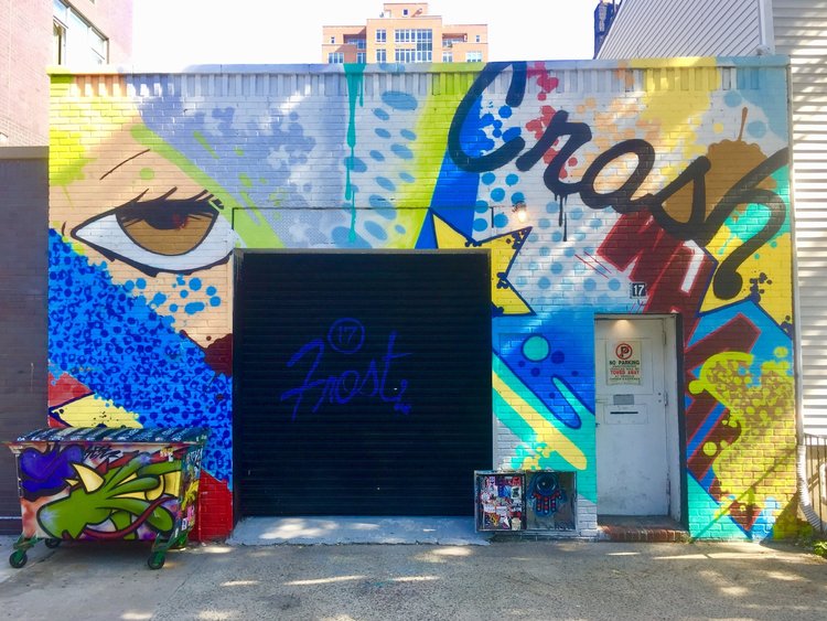 A colorful mural surrounds a venue entrance, inviting attendees to a live music event.