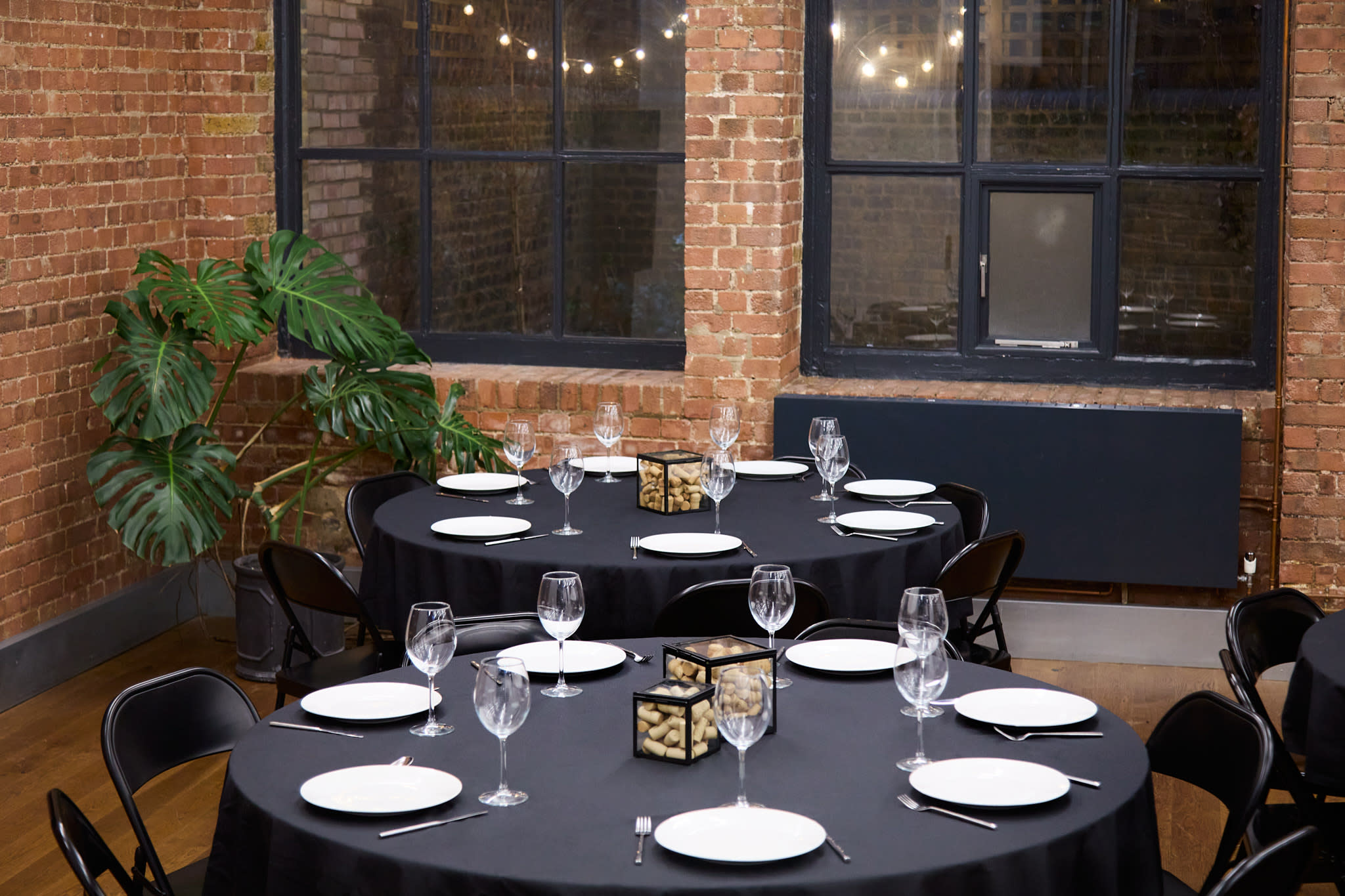 A group of friends gathers around a large table for a game night, enjoying snacks and drinks in a stylish, well-lit room.