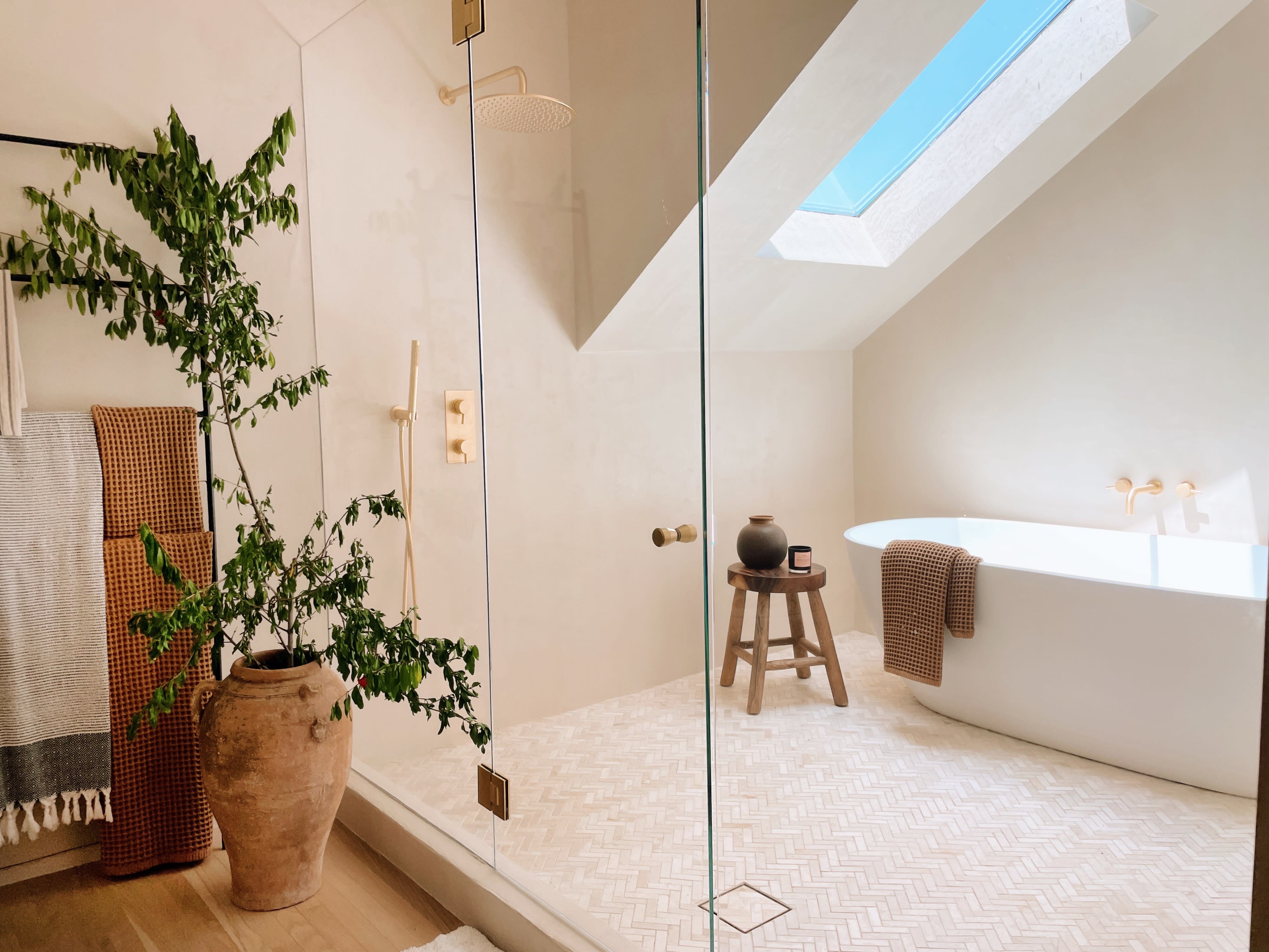 The image shows a bathroom vanity featuring a modern sink, a sleek mirror, a light fixture, and organized beauty products in a decorative box.