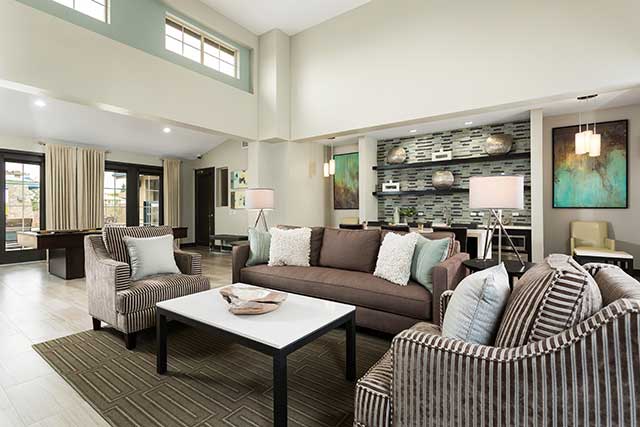 A group of people is seated and socializing in a cozy living room setting.