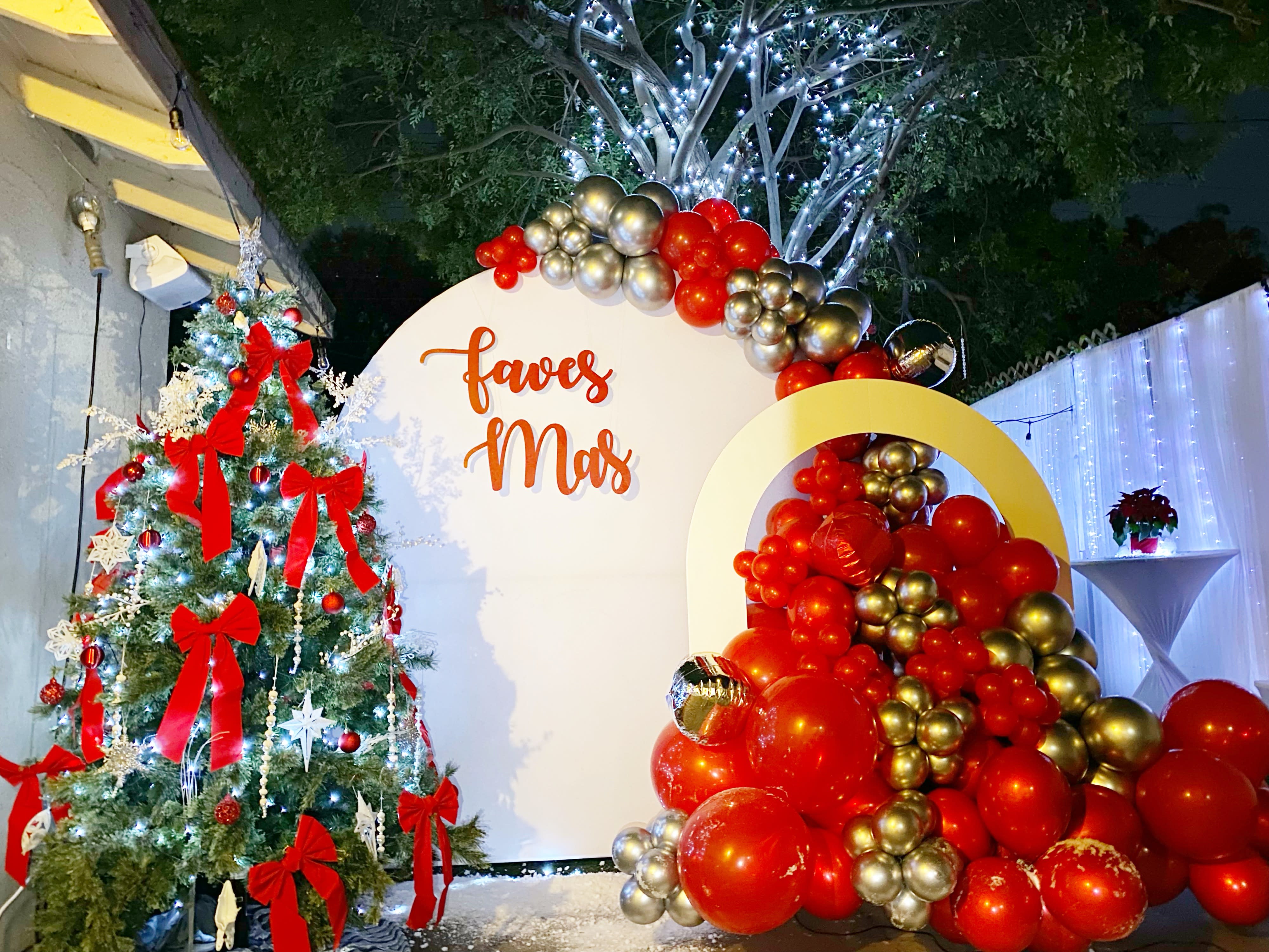 A large illuminated "GRAD" sign is displayed against a backdrop of greenery at a graduation party.
