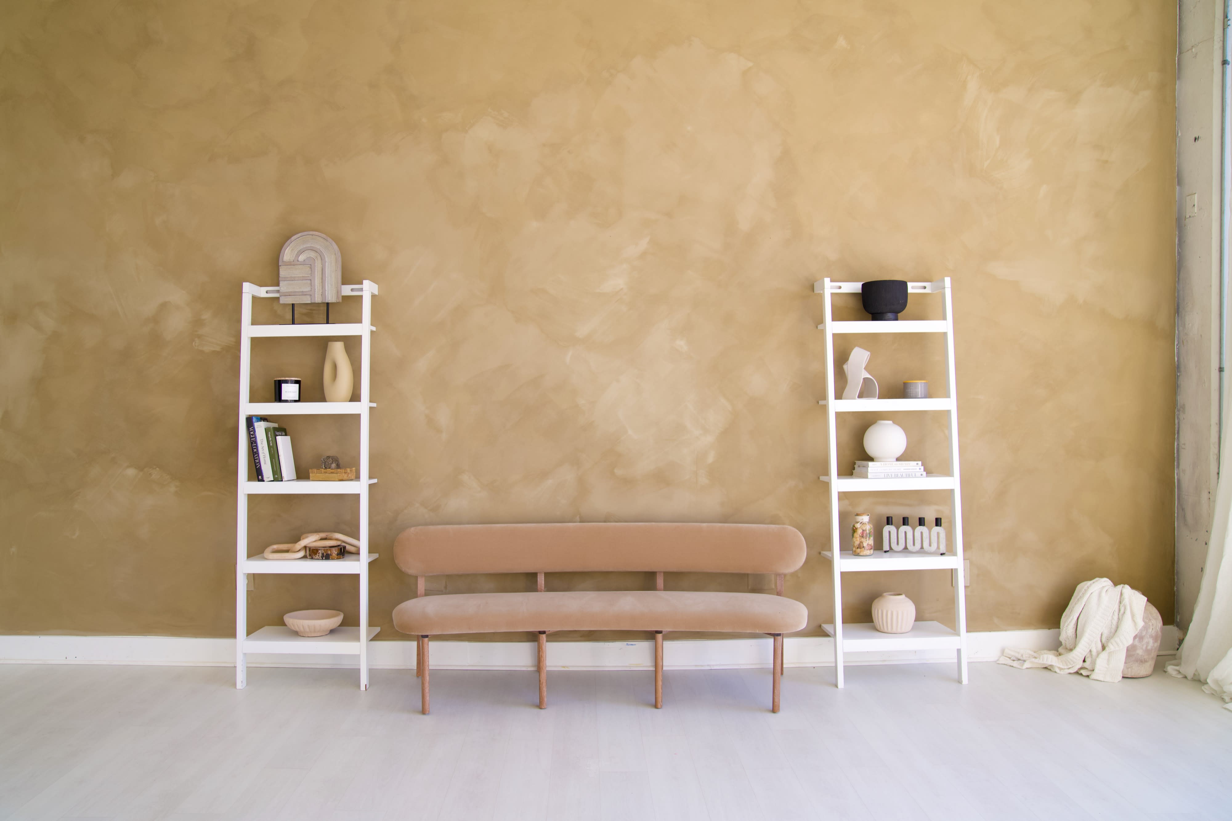 A man and a woman perform yoga poses in a bright, minimalist studio setting.