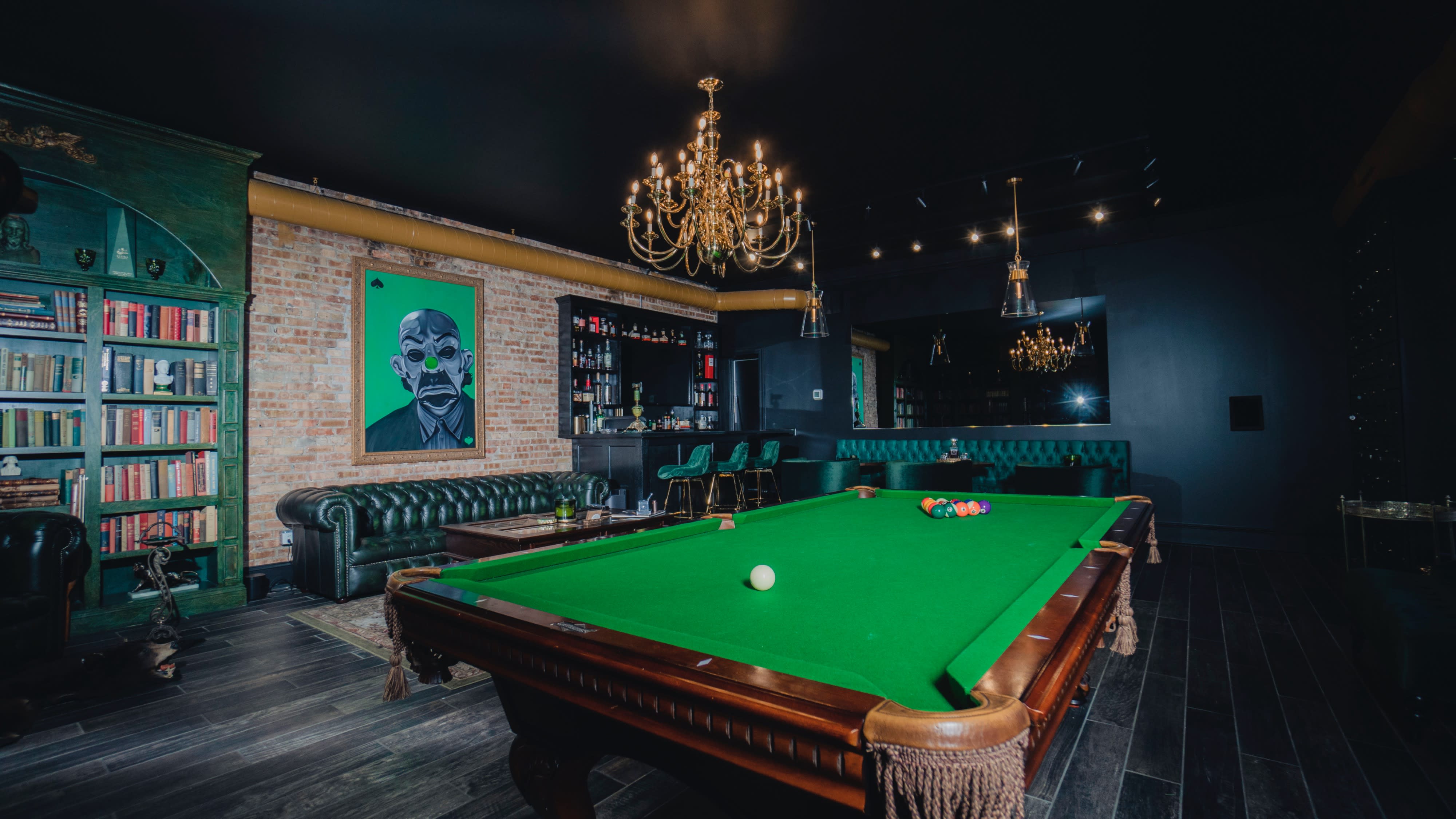 A teen birthday party is set up in a cozy room with a black leather chair, colorful balloons, and a bear rug on the floor.