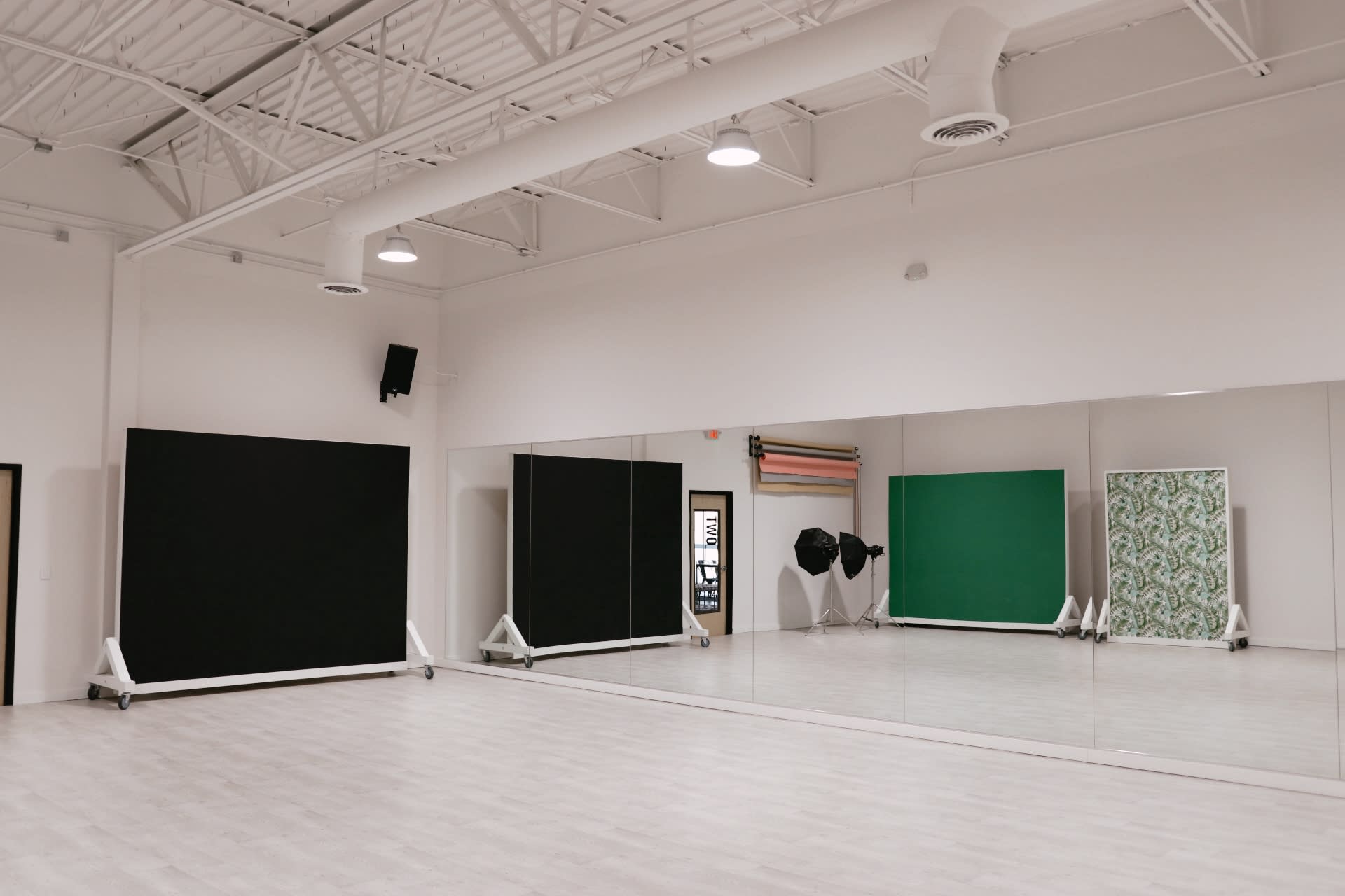 The image shows a photography studio setup with lighting equipment, a camera on a tripod, and a backdrop ready for a photoshoot.