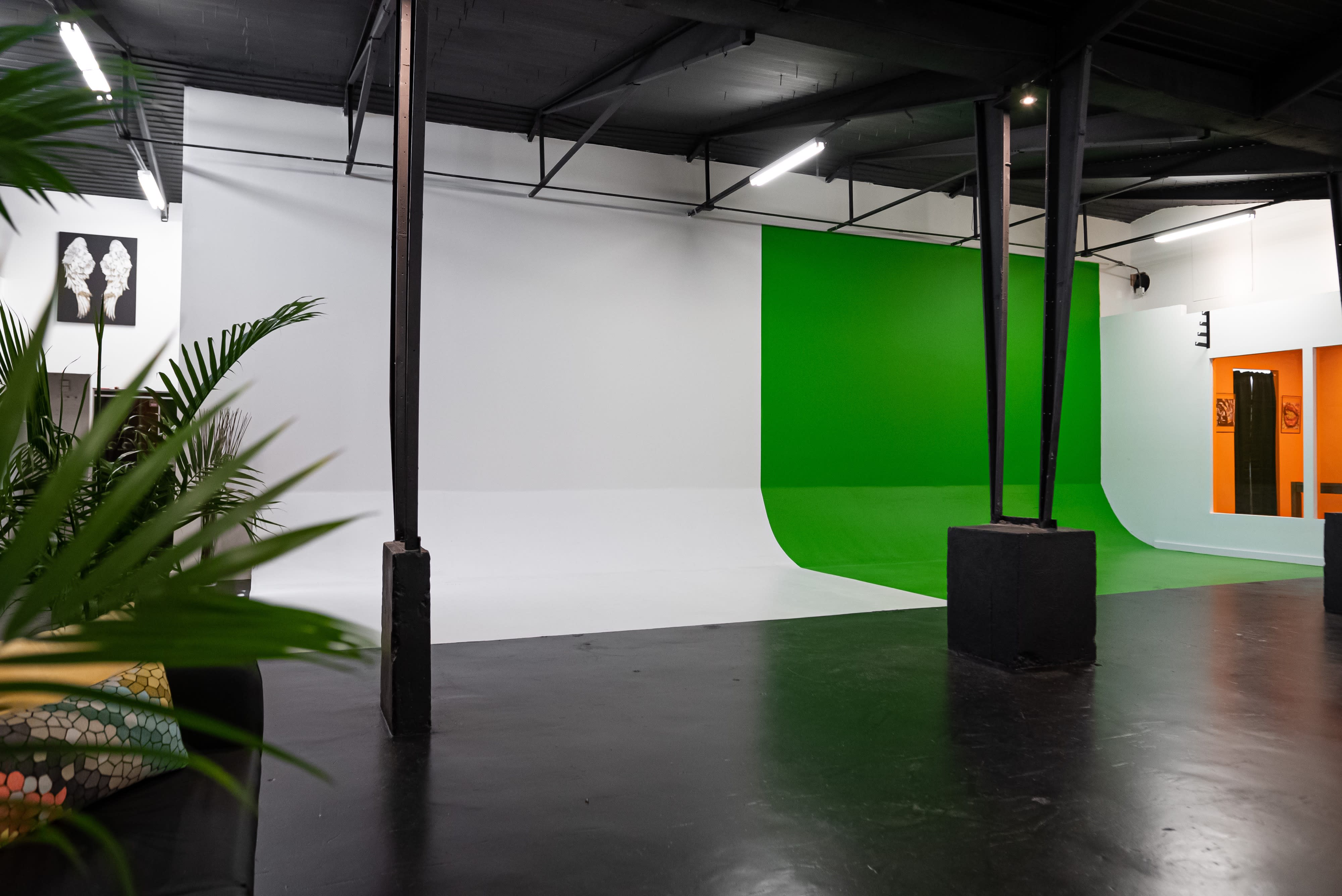 A person poses for a selfie while crouched in front of a mirror in a studio space.