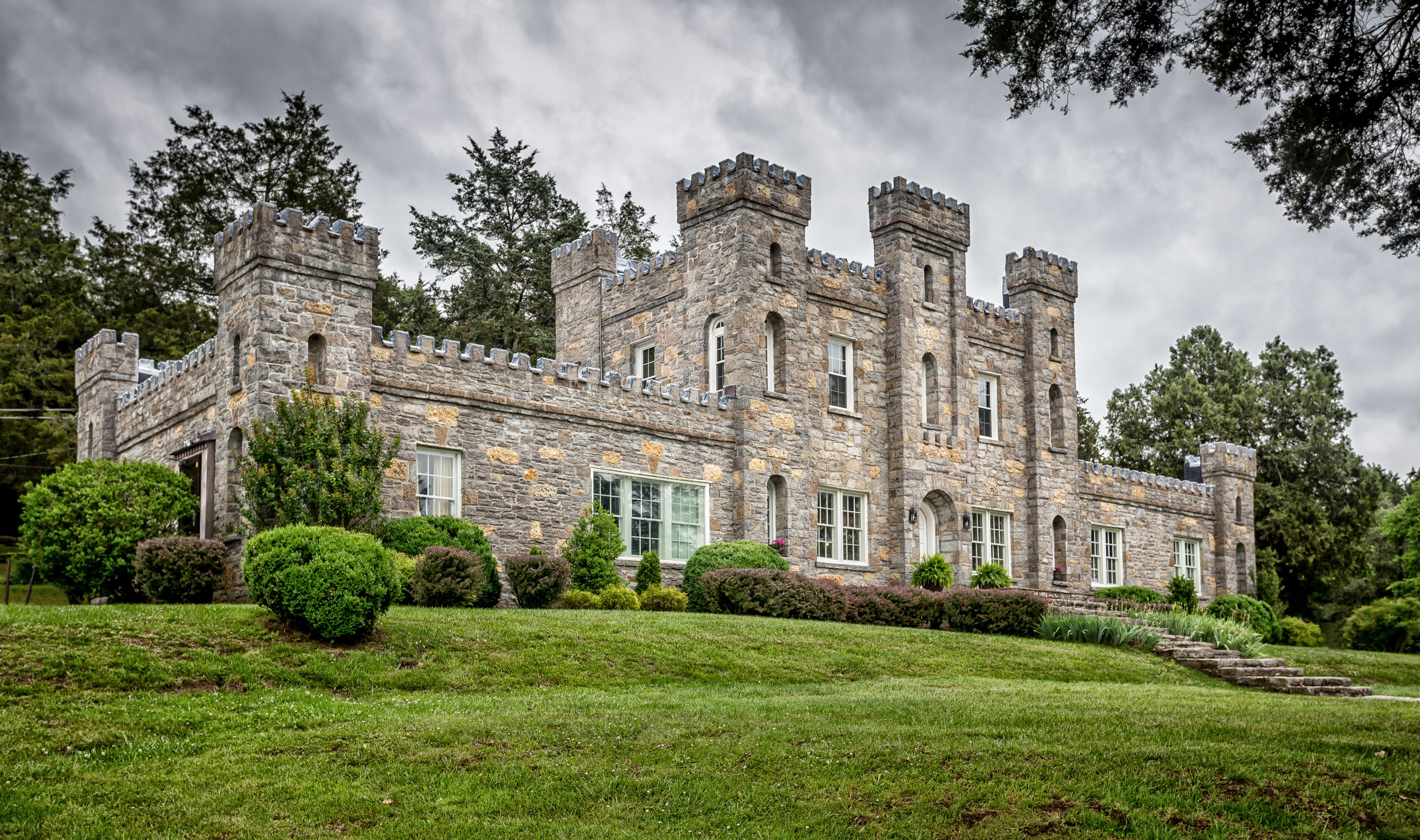 A person in a festive outfit stands on the stone steps of a castle-like building, celebrating a 30th birthday party.