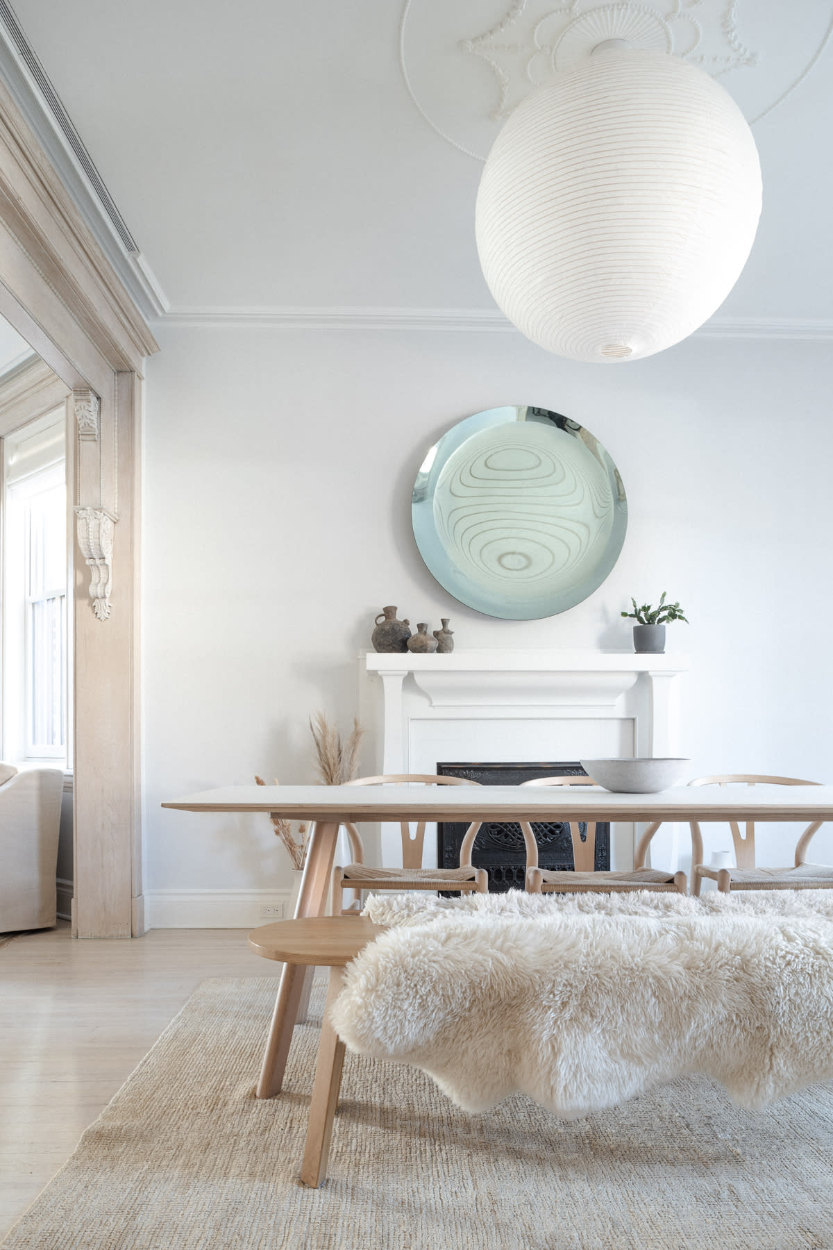 A stylish living room features a large yellow sectional sofa, a round coffee table with decor, and artwork displayed on the wall.