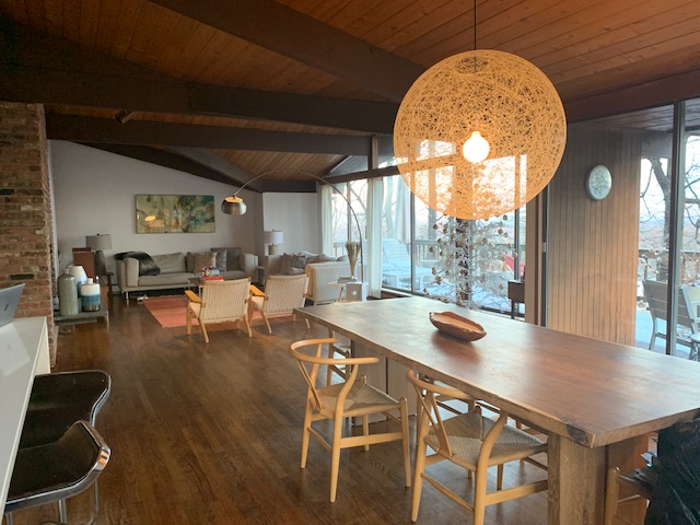 A cozy living room features two distinct seating areas with modern furniture, illuminated by warm lighting.