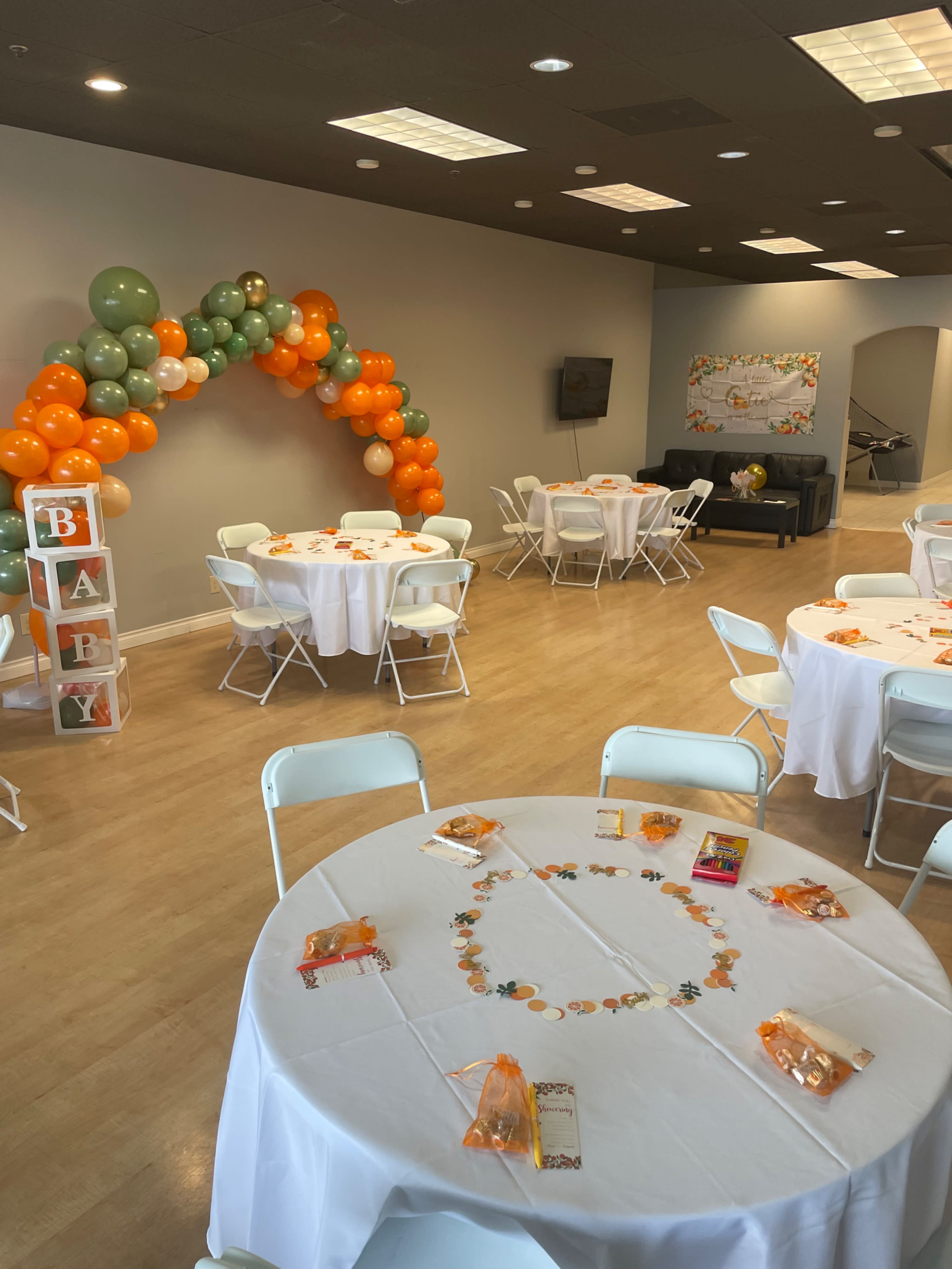 Guests celebrate a baby shower while enjoying refreshments and mingling in a decorated venue.