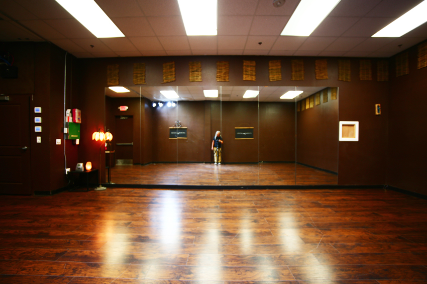 A group of individuals participates in a yoga class, engaging in various poses on yoga mats in a studio setting.