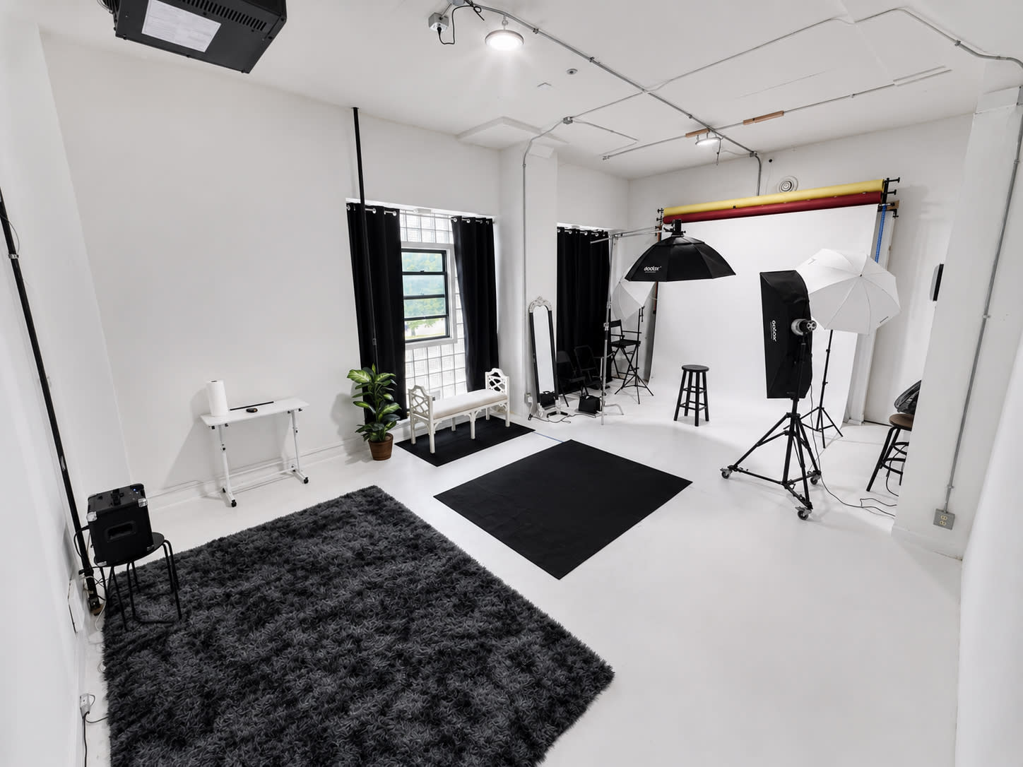A model poses with a flower in a studio setting, while the image is displayed on a laptop screen.
