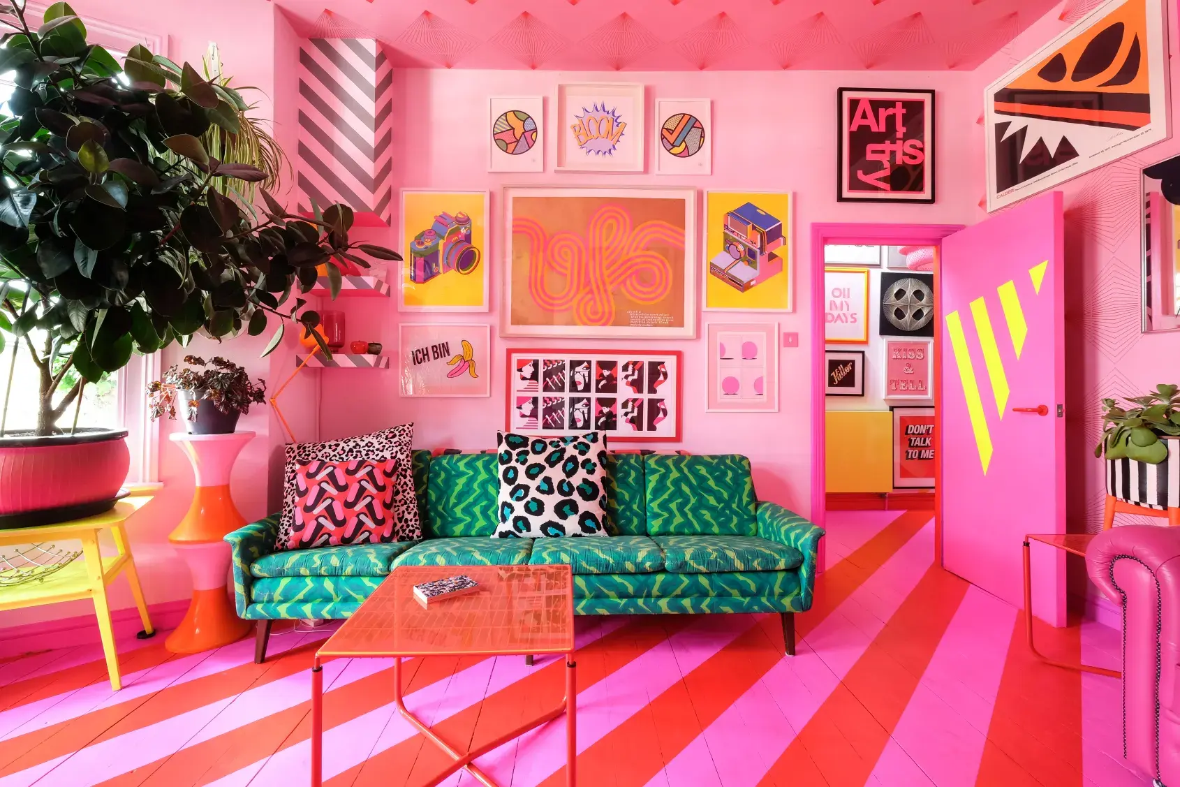 A model poses on a pink leather couch, showcasing a confident stance in a leopard print outfit during a photo shoot.
