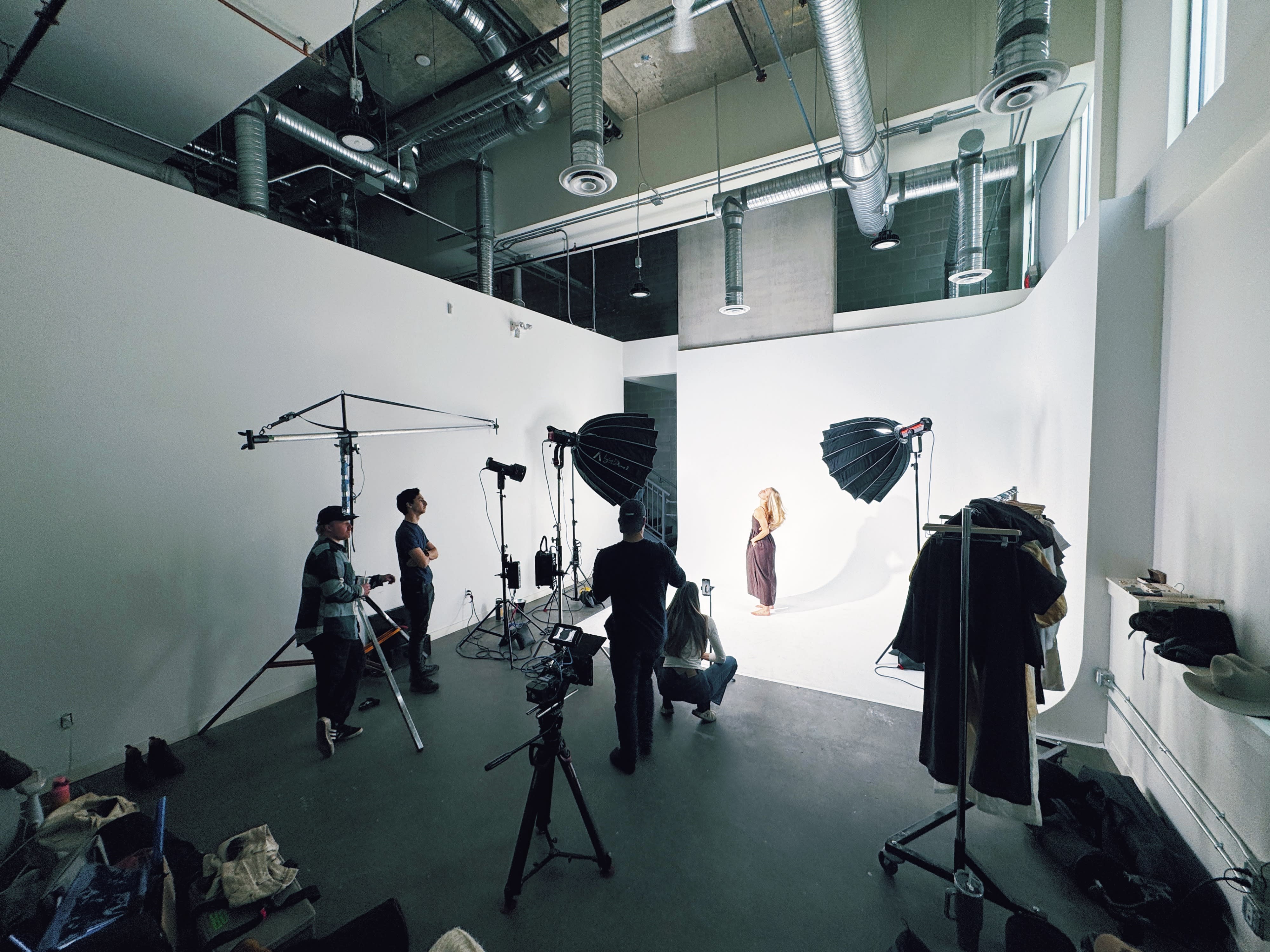 A model poses in a stylish outfit featuring a dark top and a yellow skirt during a photo shoot.